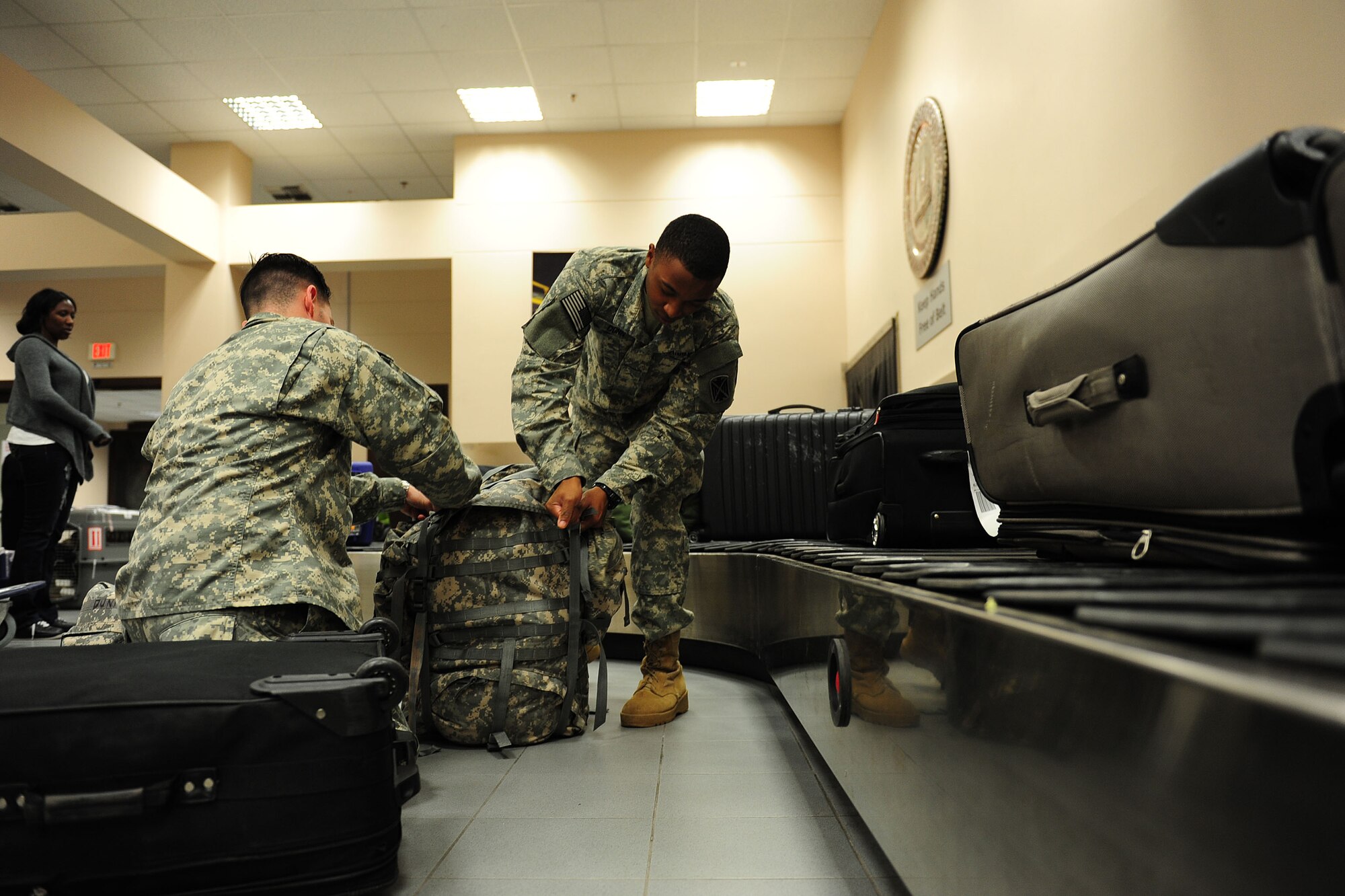 U.S. Army Sgt. Ryne Fife and Pvt. Derek Dunn, both 5788th Air Defense Artillery soldiers, claim their baggage at the 728th Air Mobility Squadron Passenger Terminal Feb. 25, 2014, Incirlik Air Base, Turkey.  Airmen from the 728th AMS play a key role in processing hundreds of passengers weekly that travel through Incirlik AB.  (U.S. Air Force photo by Senior Airman Nicole Sikorski/Released)

