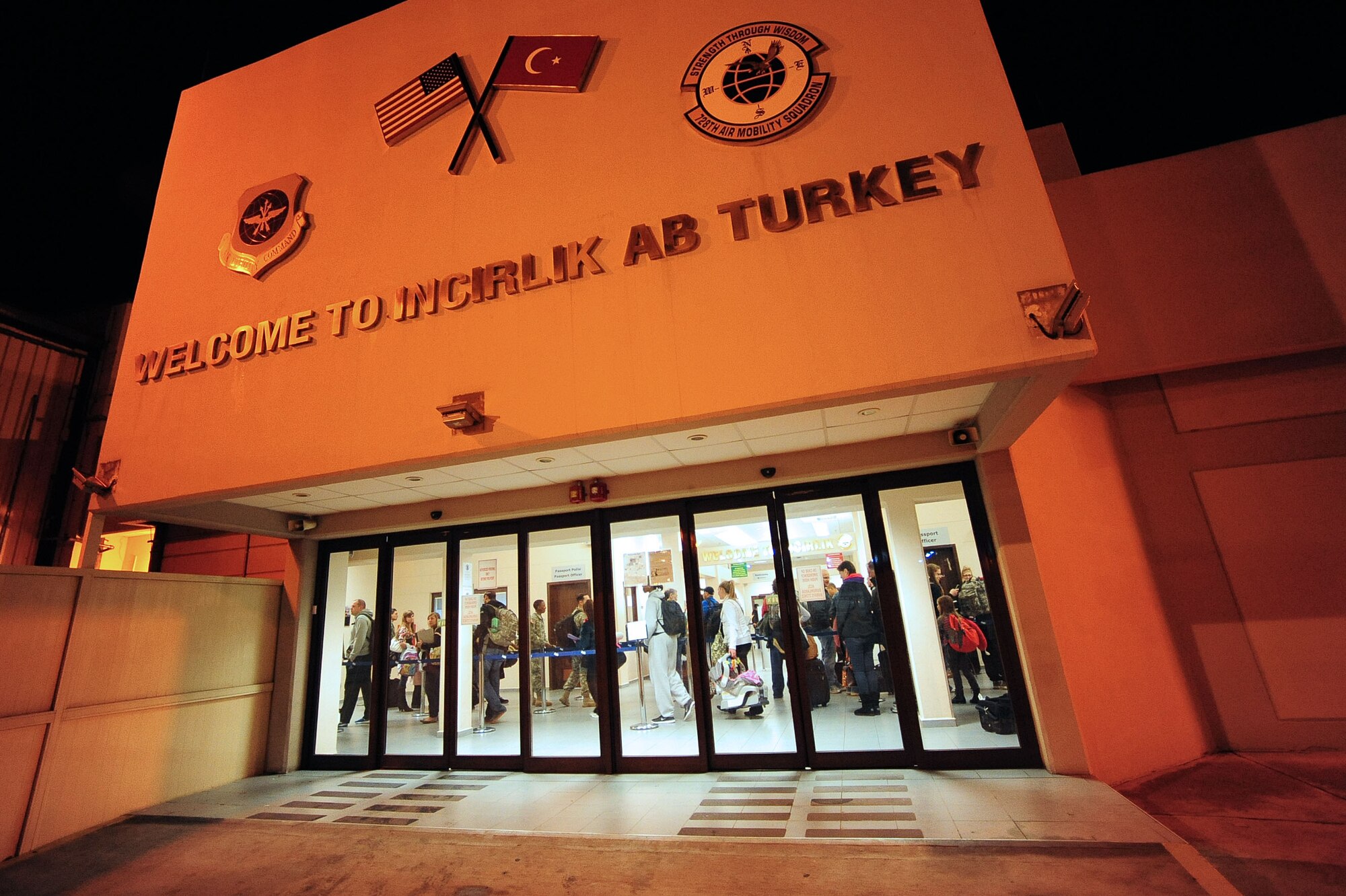 Airmen and families line up inside the 728th Air Mobility Squadron Passenger Terminal and wait to be processed through customs Feb. 25, 2014, Incirlik Air Base, Turkey. Upon arrival at customs, newcomers present their NATO orders as part of their inprocessing to Turkey. The 728th AMS processes hundreds of passengers weekly. (U.S. Air Force photo by Senior Airman Nicole Sikorski/Released)