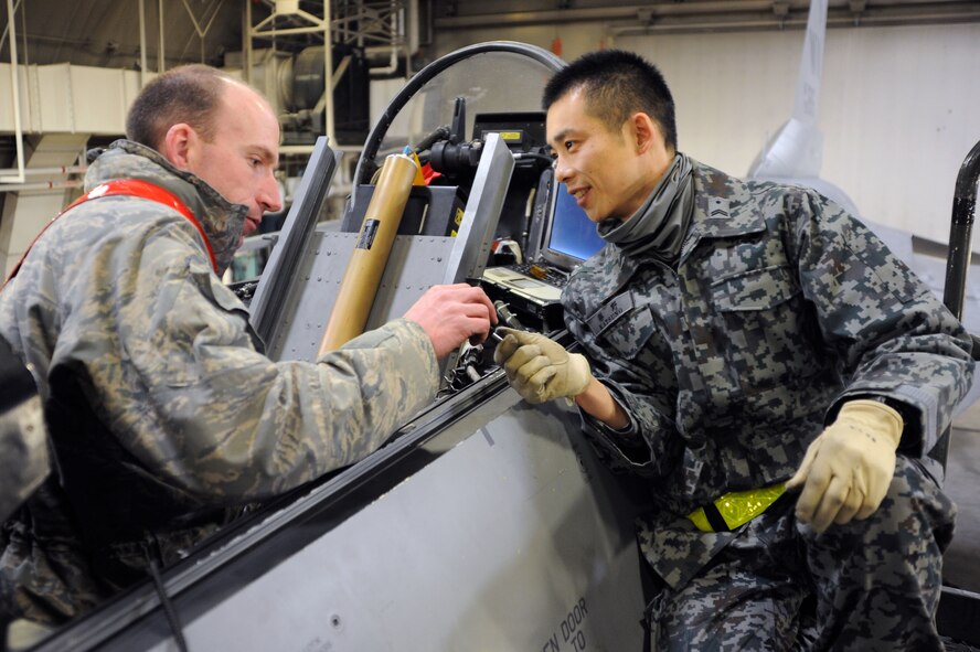 U.S. Air Force Staff Sgt. Jesse Simmons, 35th Aircraft Maintenance Squadron F-16 integrated avionics craftsman, exchanges tools with Tech. Sgt. Tomoyoshi Katsuno, Japan Air Self-Defense Force maintainer, at Misawa Air Base, Japan, Feb. 26, 2014. Maintainers and pilots worked together during Seikan War, a two-day exercise that teamed up the aerial, lethal forces of the U.S. Air Force and JASDF. (U.S. Air Force photo/Senior Airman Derek VanHorn)
