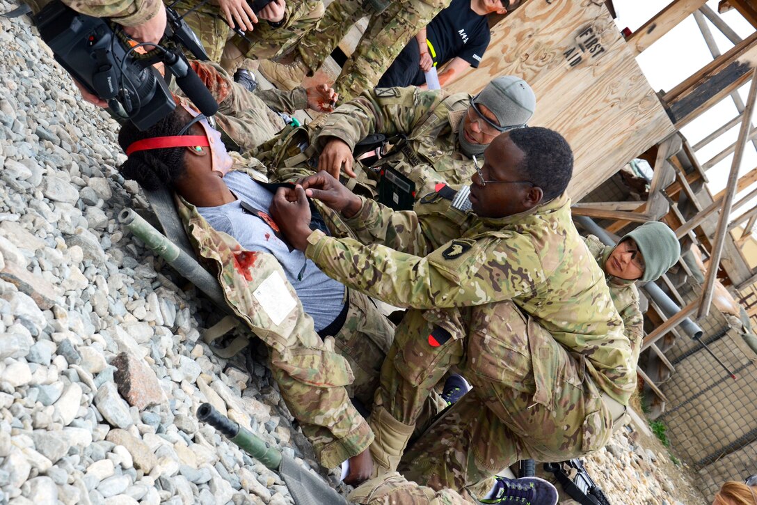 U.S. Army Spc. Travis Simmons, right foreground, helps to stabilize a simulated patient during a mass casualty exercise on Forward Operating Base Fenty, Afghanistan, Feb. 26, 2014. Simmons, a medic, is assigned to 101st Airborne Division's 159th Combat Aviation Brigade.