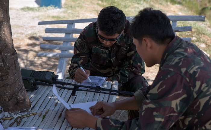 Philippine Air Force airmen discuss target locations for precision air strikes at Crow Valley Bombing Complex, Republic of the Philippines Feb. 26, as part of close-air support training during Exercise Haribon Tempest 2014. Focused on close-air support, section engaged maneuvering training and combined combat capabilities; HT 14 is a small-scale bilateral exercise between the United Sates Marine Corps and the Philippine Air Force.