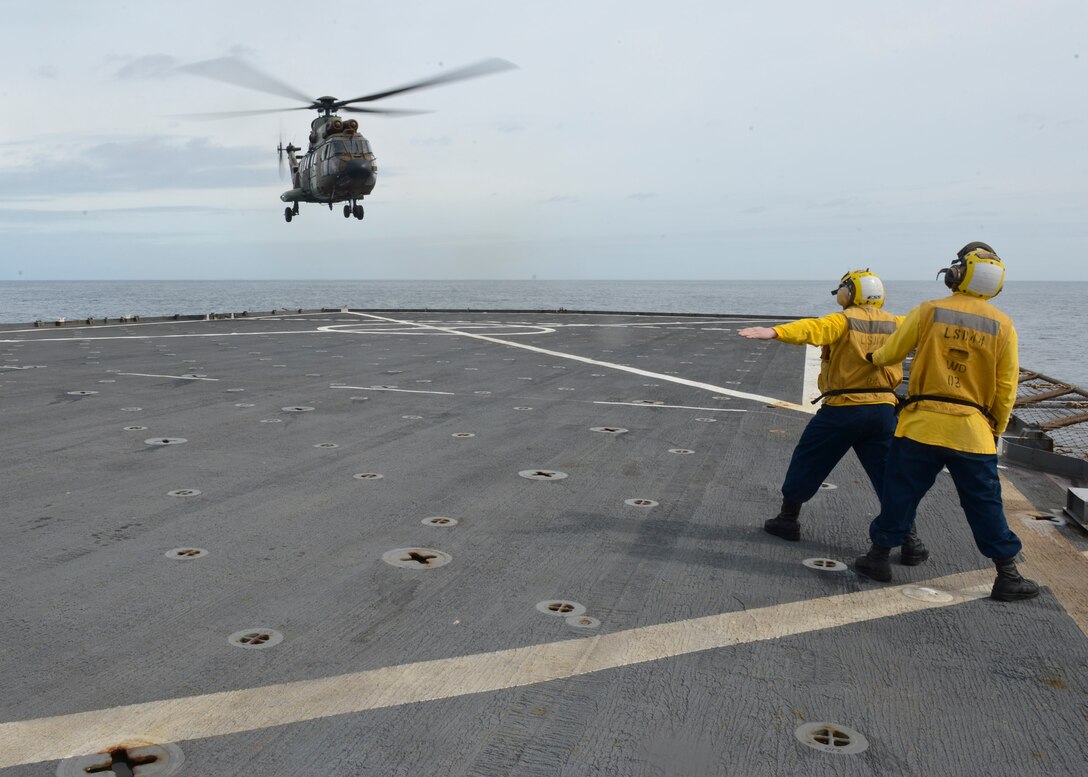 Boatswain's Mate 2nd Class Scott Hitter signals an AS-532 Cougar, from the Spanish Army, as it lands aboard the amphibious dock landing ship USS Gunston Hall (LSD-44). The carrier qualification gave the pilots from Special-Purpose Marine Air-Ground Task Force Crisis Response and Spanish Maneuver Helicopter Battalion #4 a dedicated opportunity to practice fundamental skills associated with operating carrier-based aircraft and demonstrate acceptable levels of proficiency.