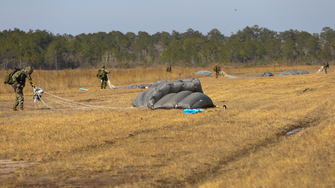 Reconnaissance men with Force Company, 2nd Reconnaissance Battalion, 2nd Marine Division, pack their parachutes after free falling from a V-22 Osprey during a field training exercise aboard Marine Corps Base Camp Lejeune, N.C., Feb. 18, 2014. Some Marines inserted through High Altitude Low Opening jumps, starting at a height of around 13,000 feet, and free falling to approximately 5,000 feet before releasing the canopy. 