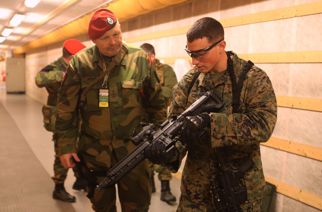 Sgt. James J. Cassidy (right), a military policeman with 2nd Supply Battalion, Combat Logistics Regiment 25, 2nd Marine Logistics Group, inspects an HK-416K assault rifle used by a Norwegian MP with Home Guard District 12 in an indoor firing range at Vaernes Garrison, Norway, Feb. 21, 2014. Two MPs attached to the battalion worked alongside their Norwegian counterparts with Home Guard District 12 to build stronger binds between the two nations’ military forces. Cold Response 2014 is a Norwegian-led multinational exercise above the Arctic Circle designed prepare for crisis response operations.  