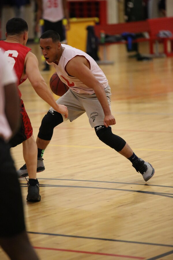 Miguel Cespedes, an Enlisted Instructor Platoon player, tries to maneuver around an opponent during an intramural basketball game against the Weapons Training Battalion at the Barber Physical Fitness Activity on Feb. 25, 2014. WTBN’s 52-34 win is their second of the year. 
