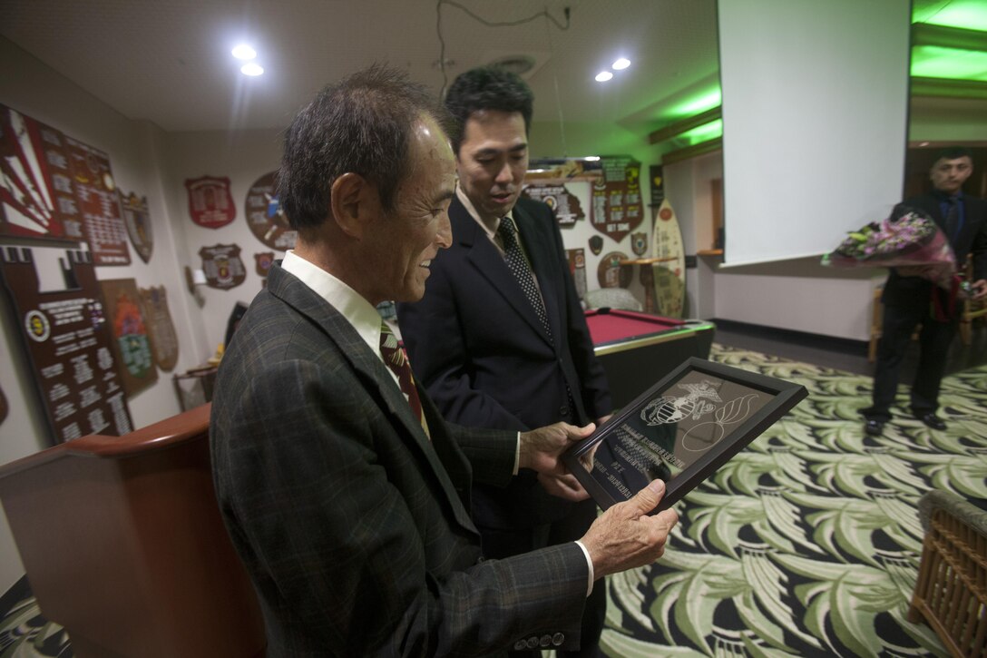 Ken Yamane, right, presents Masashi Igei with a commemorative plaque of his time with Ordnance Maintenance Company during Igei’s retirement ceremony Feb. 19 at The Palms on Camp Hansen following 47 years of service. “I’ve worked here half of my life and have really enjoyed it,” said Igei. “That’s the biggest thing to me, enjoying the job. (Now that I’m retired) I will go home to my land, work on my farm and harvest (my crops) .” Yamane and Igei are Master Labor Contract employees with the company, which is a part of 3rd Maintenance Battalion, Combat Logistics Regiment 35, 3rd Marine Logistics Group, III Marine Expeditionary Force.