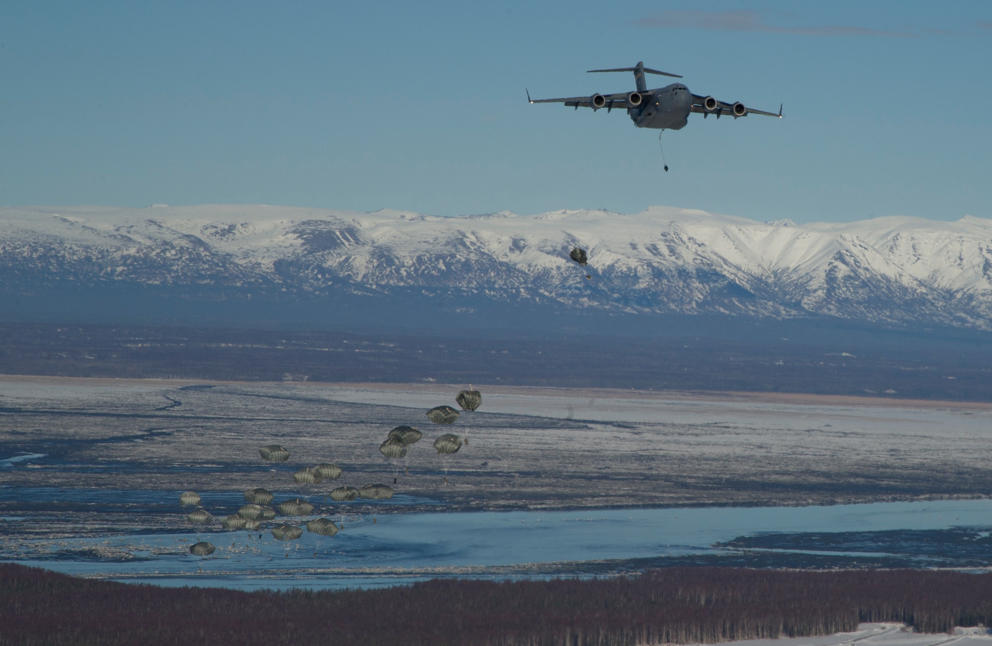 Soldiers assigned to the 725th Brigade Support Battalion, 4th Infantry Brigade Combat Team (Airborne), 25th Infantry Division, jump from an Air Force C-17 Globemaster III aircraft assigned to the 535th Airlift Squadron, Joint Base Pearl Harbor-Hickam, Hawaii, as part of the non-maneuverable canopy (T-11) personnel parachute system proficiency jump over Malemute Drop Zone, Joint Base Elmendorf-Richardson, Alaska, Feb. 27, 2014. The T-11 parachute replaced the T-10 Delta parachute that has been widely used by the Army. (U.S. Air Force photo/Staff Sgt. Sheila deVera)
