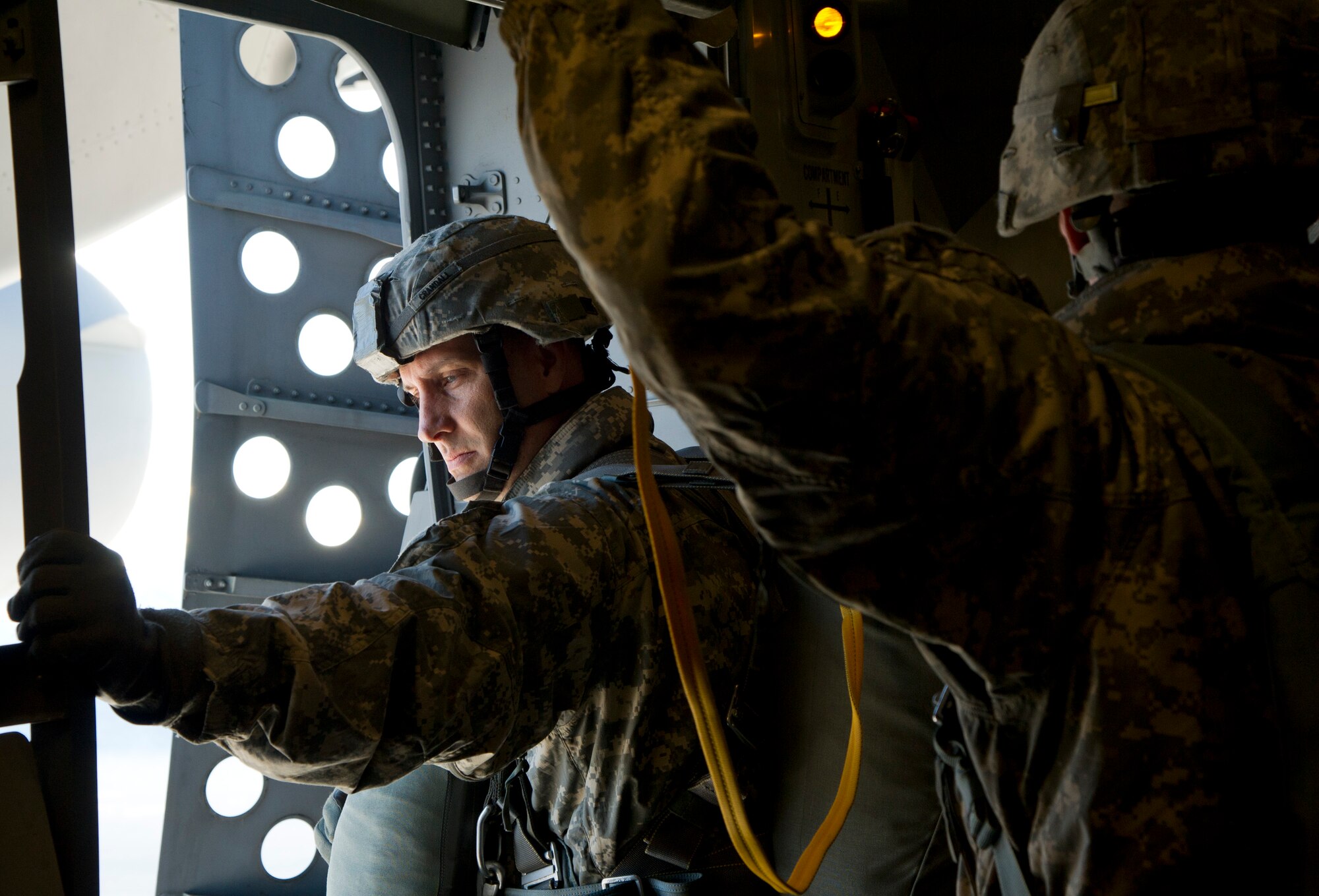Army Lt. Col. Peter Crandall, jumpmaster, looks out the door as they prepare to jump from a C-17 Globemaster III from the 517th Airlift Squadron over Malemute Drop Zone at Joint Base Elmendorf-Richardson, Alaska, Feb. 27, 2014. Jumpmasters are the expert paratroopers who train and teach Soldiers techniques for jumping from airplanes. Crandall is assigned to 725th Brigade Support Battalion, 4th Infantry Brigade Combat Team (Airborne), 25th Infantry Division.  (U.S. Air Force photo/Staff Sgt. Sheila deVera)