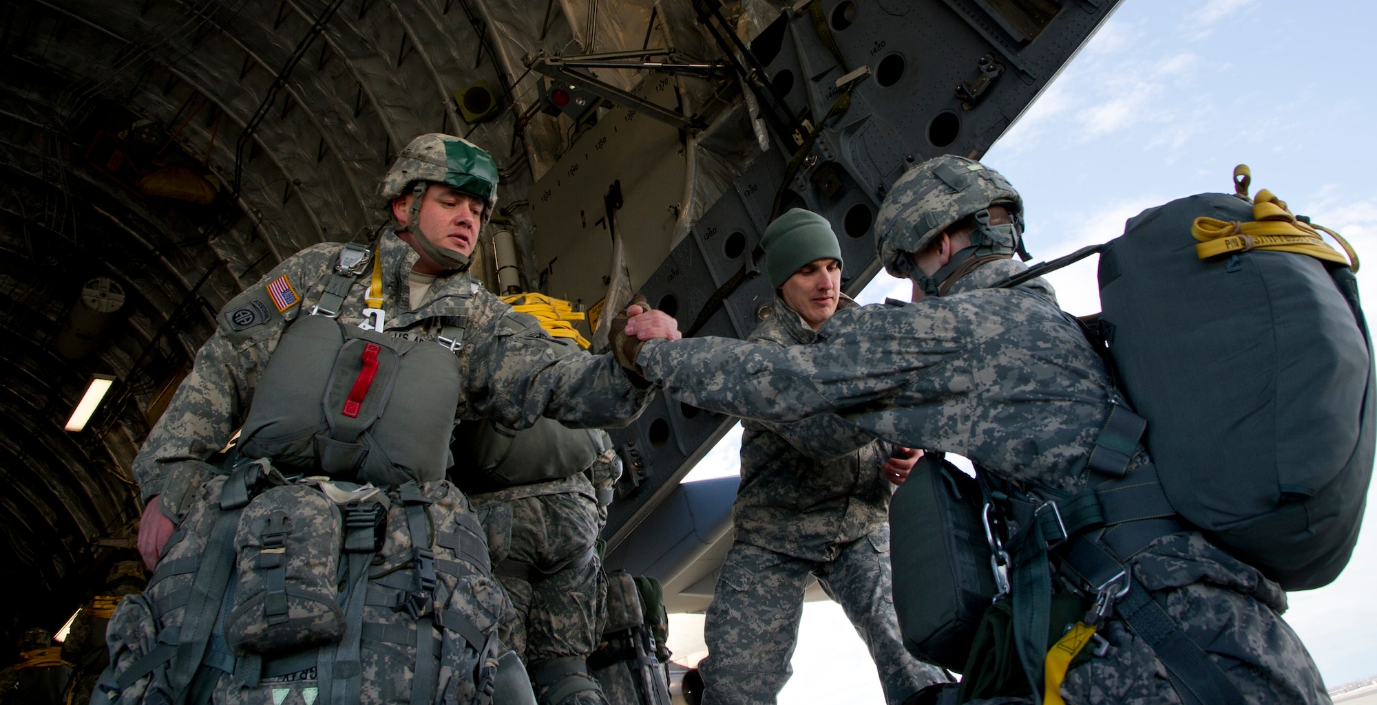 Sgt. 1st Class Kenneth Gray assigned to the 425th Brigade Special Troops Battalion, 4th Infantry Brigade Combat Team (Airborne), 25th Infantry Division, helps a fellow Soldier board a C-17 Globemaster III, Feb. 27, 2014, at Joint Base Elmendorf-Richardson, Alaska. The 425th BSTB conducted a non-maneuverable canopy T-11 personnel parachute system proficiency jump over Malemute Drop Zone. (U.S. Air Force photo/Staff Sgt. Sheila deVera)