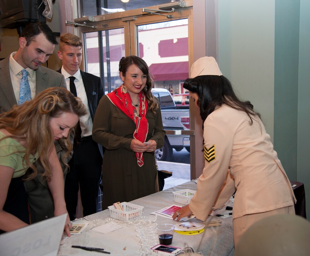 A group of attendees sign in at the front door of the Laughlin Officer Spouses’ Club auction to receive their auction paddles at the J.P. Kress building in Del Rio, Texas, March 1, 2014. The OSC auction helps raise money for scholarships for local students. (U.S. Air Force photo/Airman 1st Class Jimmie D. Pike)