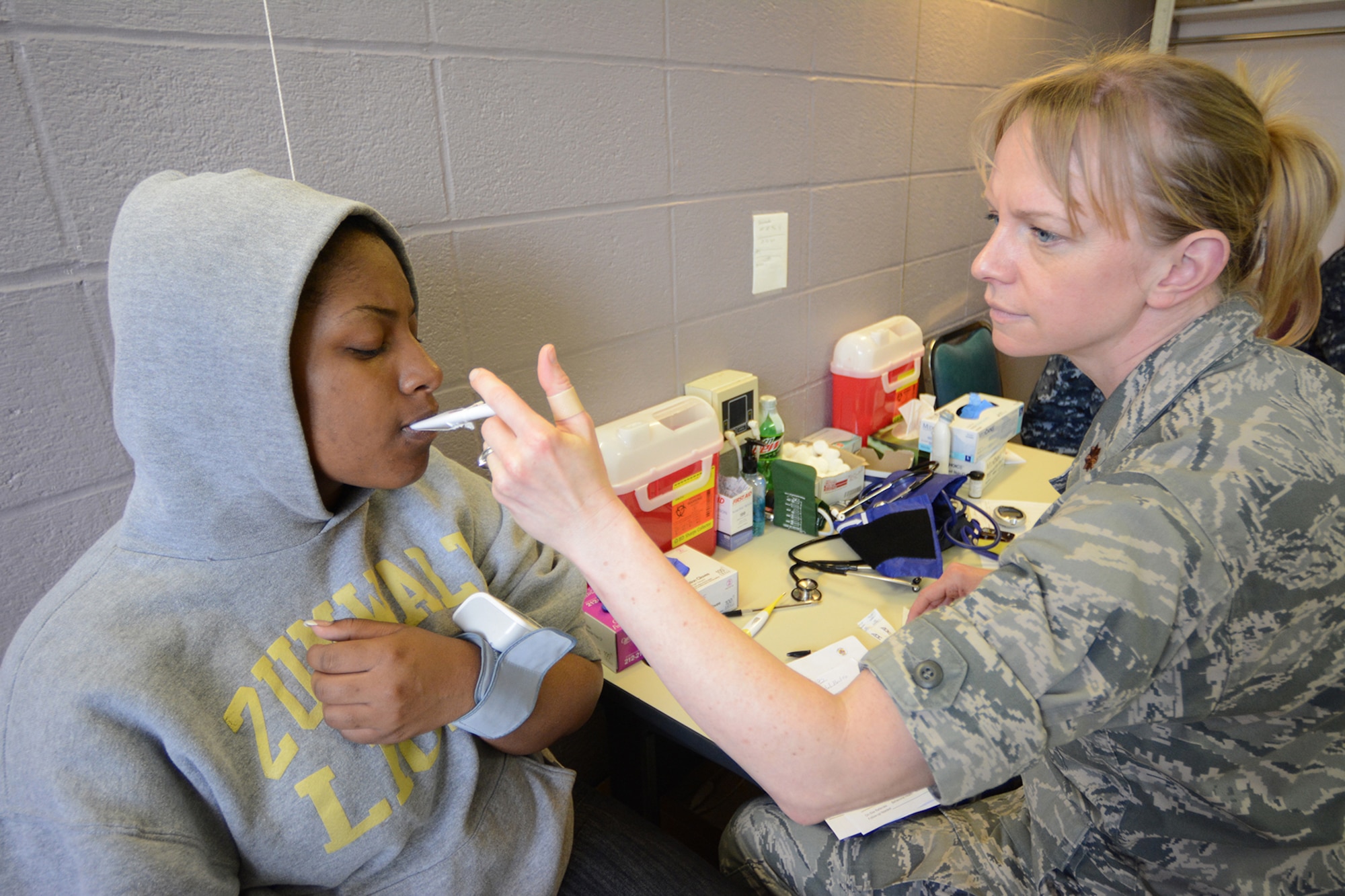 Maj. Rachel Neisner, 173rd Medical Group, checks the vitals on her patient during Cajun Care 2014 in Abbeville, La., March 2, 2014. After the eighth day of the 10-day mission, Air National Guard, Navy and Army personnel had already given free medical care to more than 2,100 people. (Air National Guard photo by Senior Airman Andrea F. Liechti)