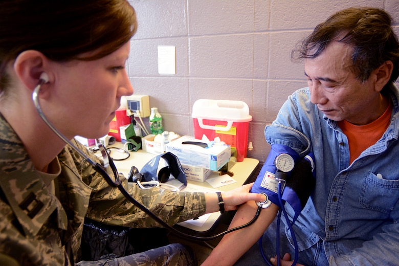 Capt. Erin Lutterman, 115th Medical Group registered nurse, checks the vitals on her patient during Cajun Care 2014 in Abbeville, La., March 2, 2014. After the eighth day of the 10-day mission, Air National Guard, Navy and Army personnel had already given free medical, dental and optometry care to more than 2,100 people. (Air National Guard photo by Senior Airman Andrea F. Liechti)