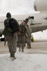 Airmen from the 5th Maintenance Group and 5th Operations Support Squadron board their plane headed to Andersen Air Force Base, Guam, for a six month deployment at Minot AFB, N.D., March 5, 2014. This deployment demonstrates the U.S.’s continuous commitment to stability and security in the Asia-Pacific Region. (U.S. Air Force photo/Senior Airman Brittany Y. Auld)
