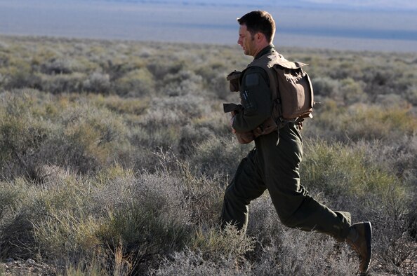 U.S. Air Force 1st Lt. Ryan Gipson, 336th Fighter Squadron F-15E Strike Eagle pilot, runs across a field of brush in Southern Nevada March 4, 2014, during Red Flag 14-2. Gipson spent more than four hours eluding “enemy forces” using skills he learned during survival, evasion, resistance and escape training. (Air Force photo/Staff Sgt. Chuck Broadway)