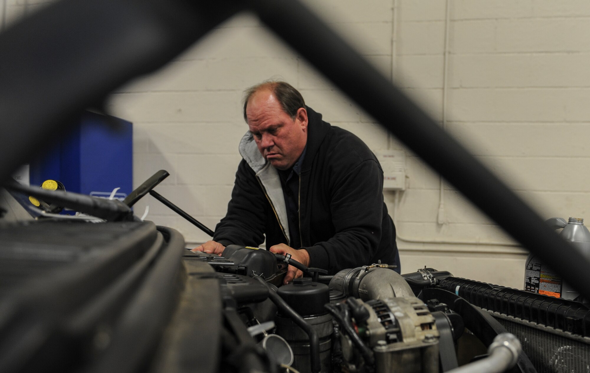 John Butler, 23d Logistics Readiness Squadron heavy mobile equipment mechanic, reattaches the radiator overflow reservoir to a vehicle at Moody Air Force Base, Ga., March 5, 2014.  Butler checked the level of coolant to make sure the vehicle’s radiator was running properly. (U.S. Air Force photo by Airman 1st Class Alexis Millican/Released)