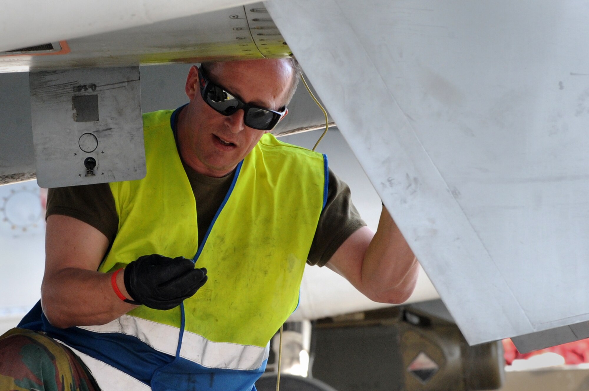 A crew chief with the 350th Squadron, Royal air force Belgium, inspects the fuselage of an F-16 Fighting Falcon at Nellis Air Force Base, Nev., March 3, 2014. As part of Red Flag 14-2, the Belgian Airmen conducted operations alongside U.S. and other coalition nations to enhance joint operations capabilities. (Air Force photo/Staff Sgt. Chuck Broadway)