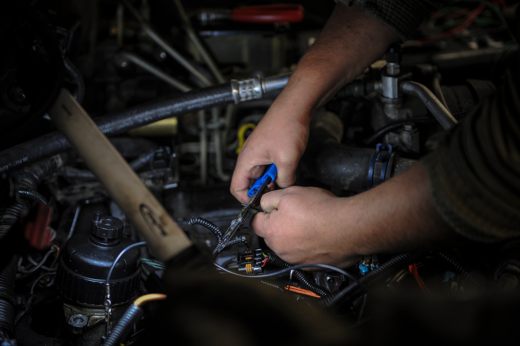 U. S. Air Force Senior Airman Josh Flodder, 23d Logistics Readiness Squadron vehicle vehicular equipment maintenance journeyman, strips a wire while performing maintenance on a vehicle at Moody Air Force Base, Ga., March 5, 2014. The vehicle maintenance shop is responsible for keeping Moody’s nearly 500 vehicles running. (U.S. Air Force photo by Airman 1st Class Alexis Millican/Released)