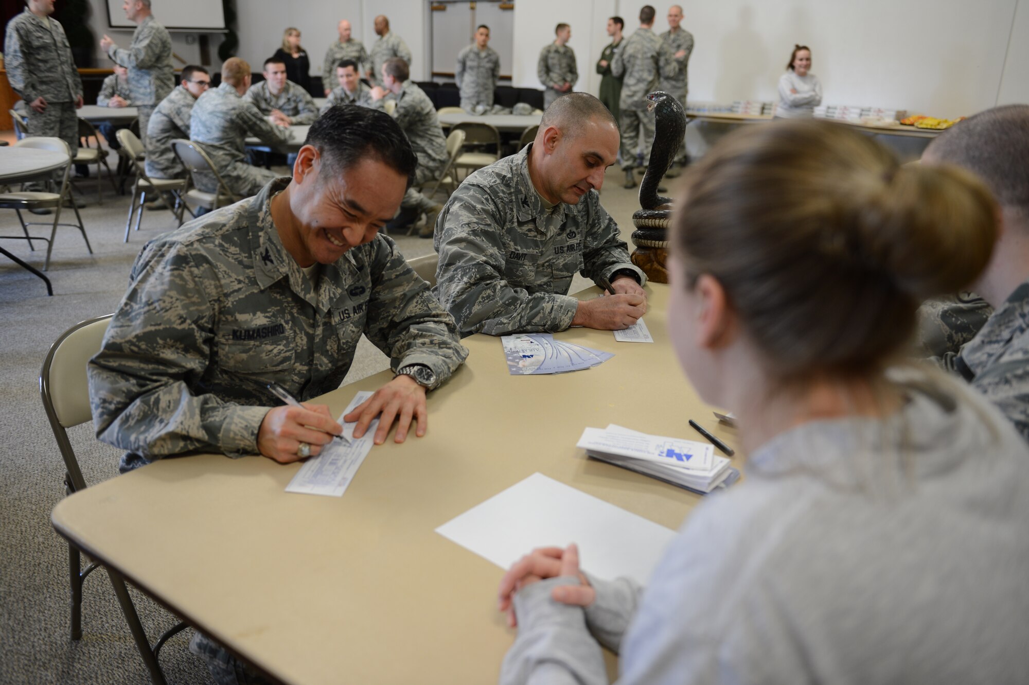 Col. David Kumashiro (left), 62nd Airlift Wing commander and Col. Tony Davit (right), 627th Air Base Group commander, sign their Air Force Assistance Fund forms as part of the Team McChord AFAF kick-off event at the McChord Field Chapel Support Center, Feb. 28, 2014 at Joint Base Lewis-McChord, Wash. The AFAF campaign dates are March 3 through April 11 and the focus of this year's campaign is "Taking Care of Our Own." (U.S. Air Force photo/Master Sgt. Todd Wivell)
 