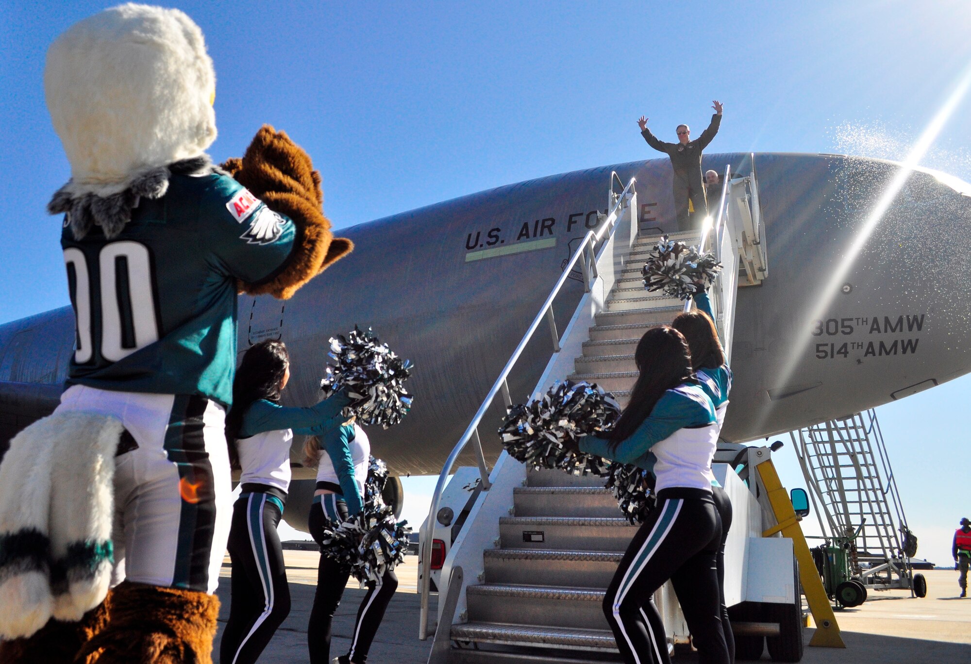 Col. Jonathan Spare raises his arms in joy as wing members, Swoop and the Philadelphia Eagles cheerleaders celebrate the vice commander's fini-flight here Feb. 23