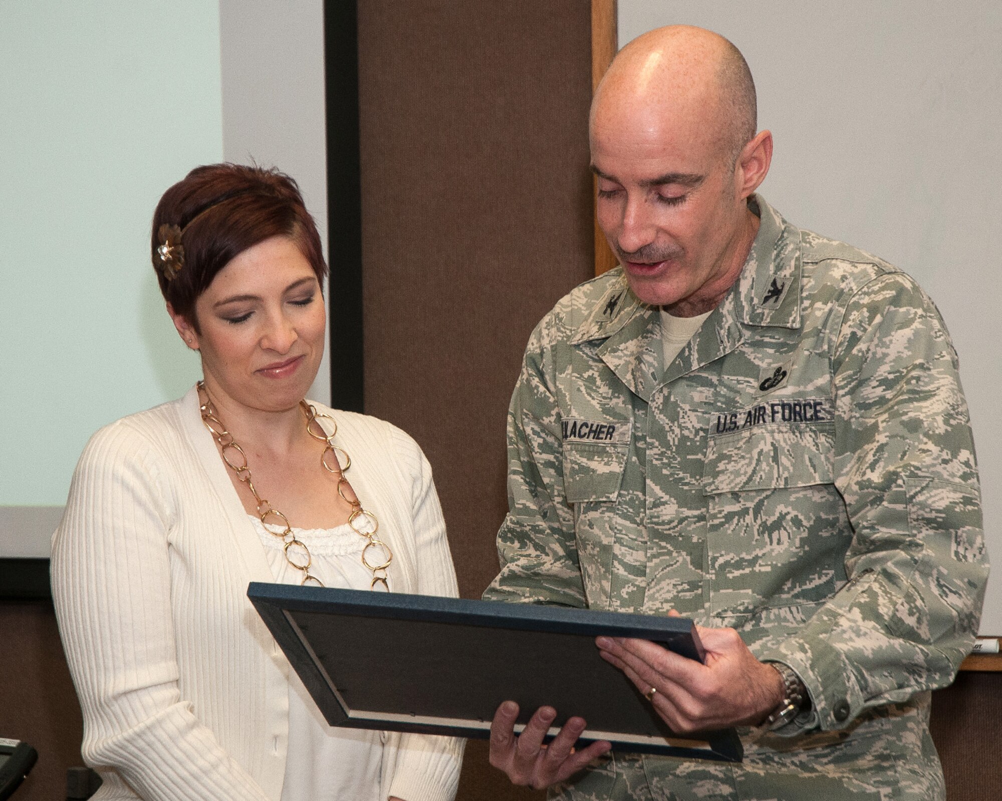 HANSCOM AIR FORCE BASE, Mass. – 66th Air Base Group Commander Col. Lester A. Weilacher reads an award to Monica Hyatt before presenting her the Hanscom Key Spouse of the Year award at the Airman and Family Readiness Center March 5. Hyatt was presented the award prior to a training session for Key Spouse members. (U.S. Air Force photo by Mark Herlihy)