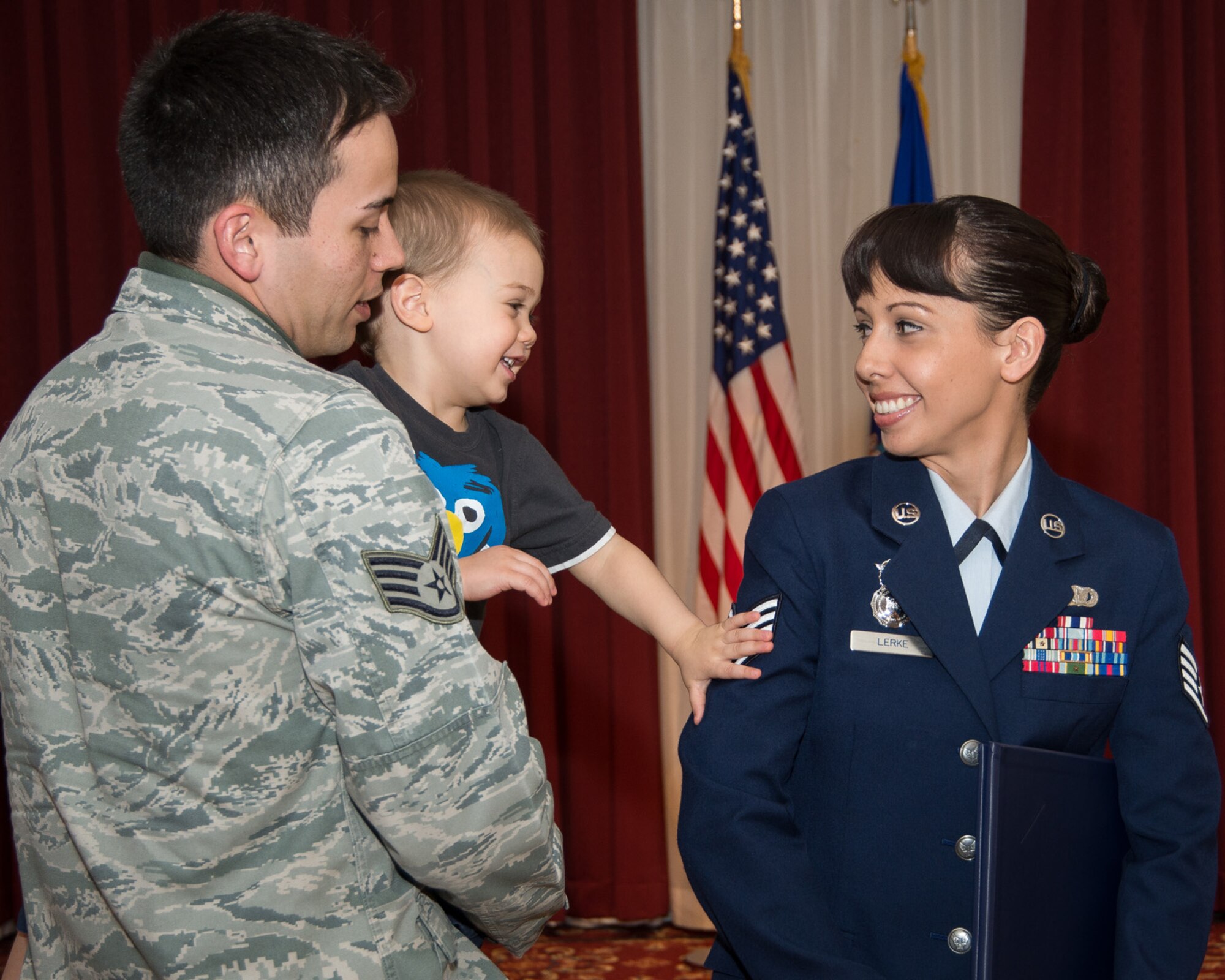 HANSCOM AIR FORCE BASE, Mass. –Staff Sgt. J.R. Robbins, 66th Security Forces Squadron, two year old Connor as he tacks staff sergeant stripes on his mom, newly promoted Staff Sgt. Ashley Lerke, 66th Security Forces Squadron, during the monthly enlisted promotion ceremony at the Minuteman Commons, Feb. 28. The ceremony is held towards the end of the month and is an opportunity for the Hanscom community to recognize the enlisted members who have been selected for promotion. (U.S. Air Force photo by Mark Herlihy)	