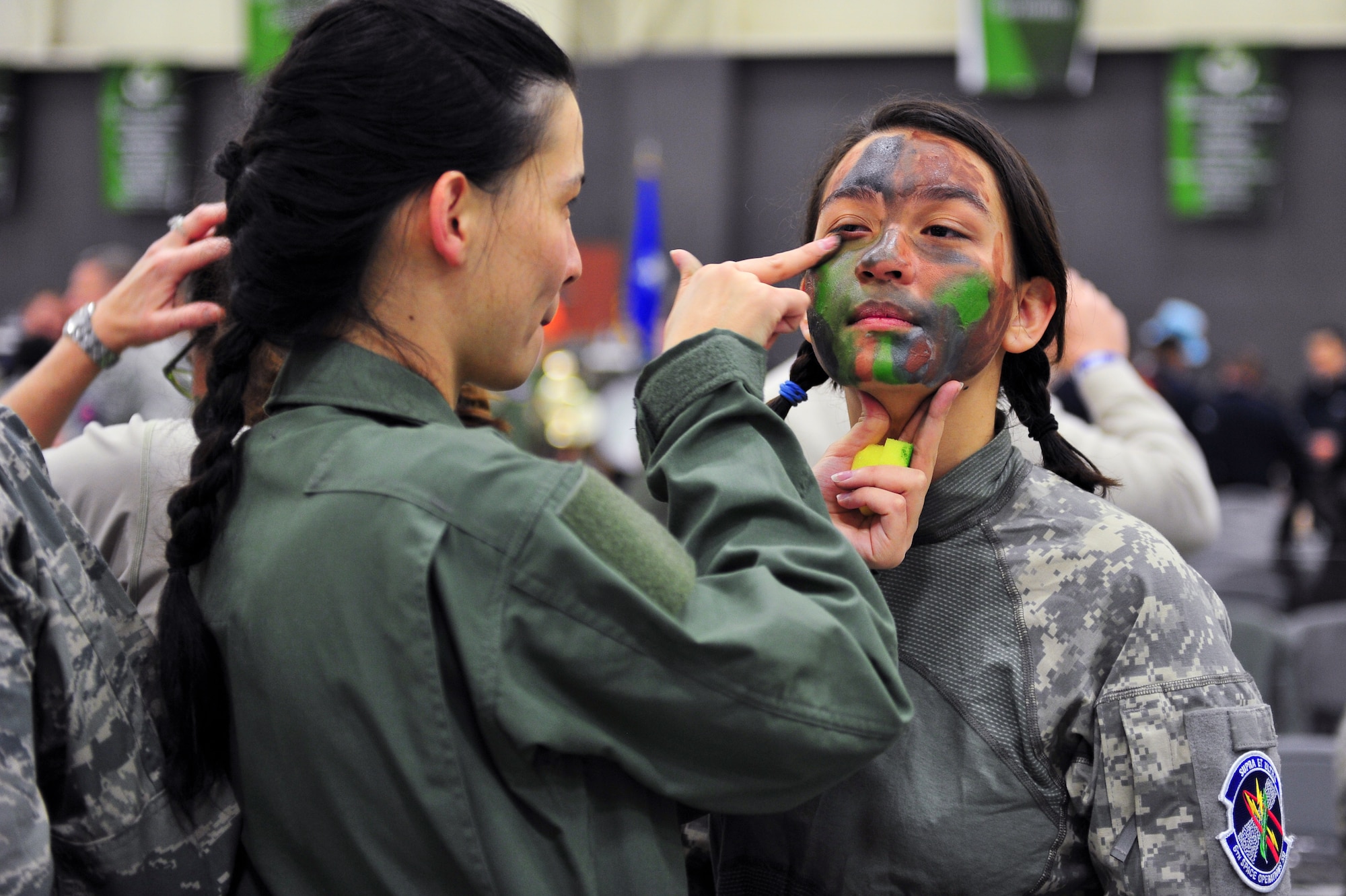 One of several Air Force Reservists has camouflage makeup applied March 1, 2014, before the start of the 310th Space Wing's Combat Dining In/Annual Awards Ceremony at Peterson Air Force Base, Colo. The wing sponsored the event to both recognize its annual award winners and bring together the Reservists to enjoy an evening of esprit de corps, unit morale and camaraderie. (U.S. Air Force photo/Tech. Sgt. Nicholas B. Ontiveros)