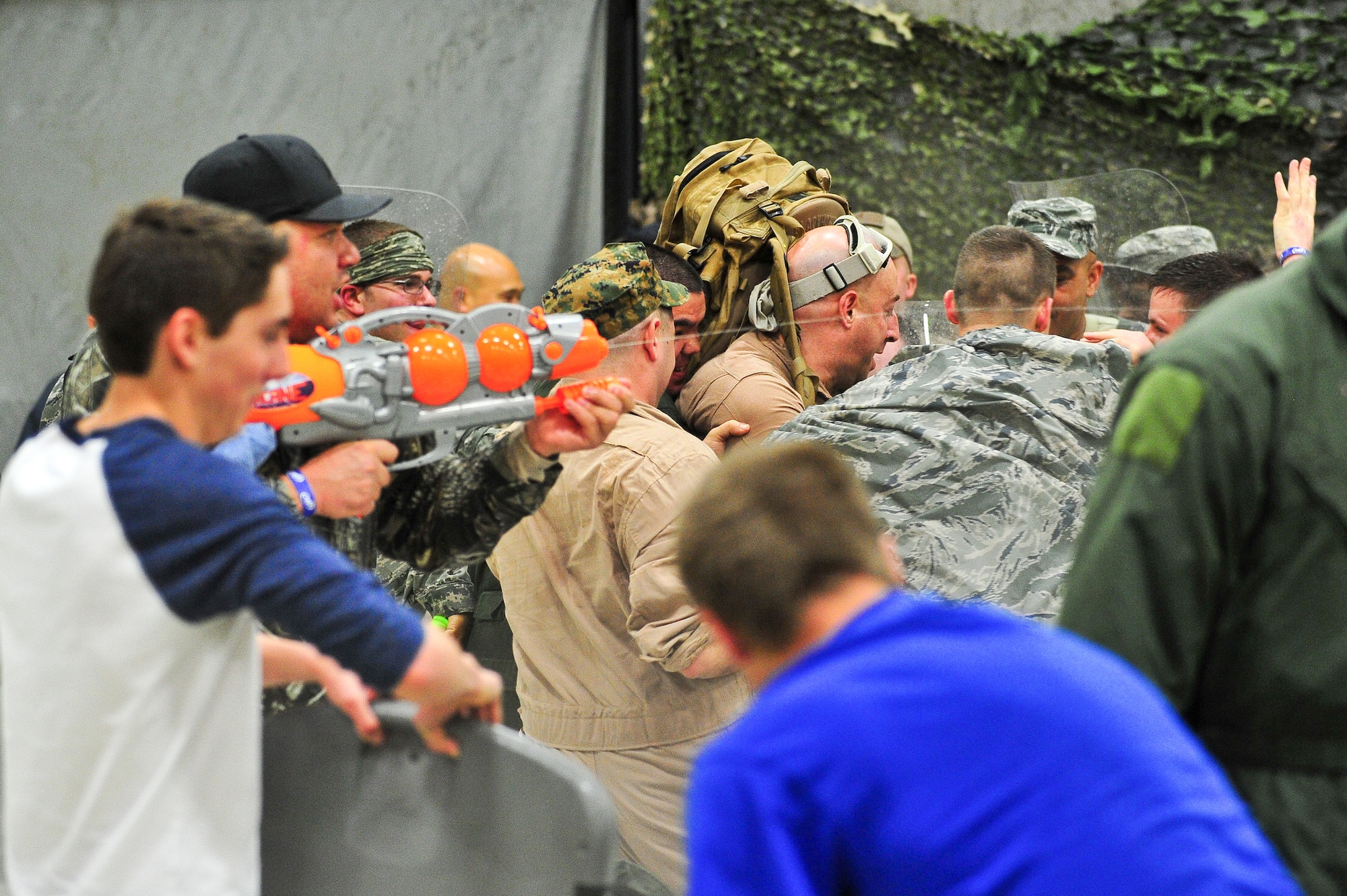 Air Force Reservists fire water gun warning shots to keep back opposing fellow Airmen March 1, 2014, during the 310th Space Wing's Combat Dining In/Annual Awards Ceremony at Peterson Air Force Base, Colo. The wing sponsored the event to both recognize its annual award winners and bring together the Reservists to enjoy an evening of esprit de corps, unit morale and camaraderie. (U.S. Air Force photo/Tech. Sgt. Nicholas B. Ontiveros)