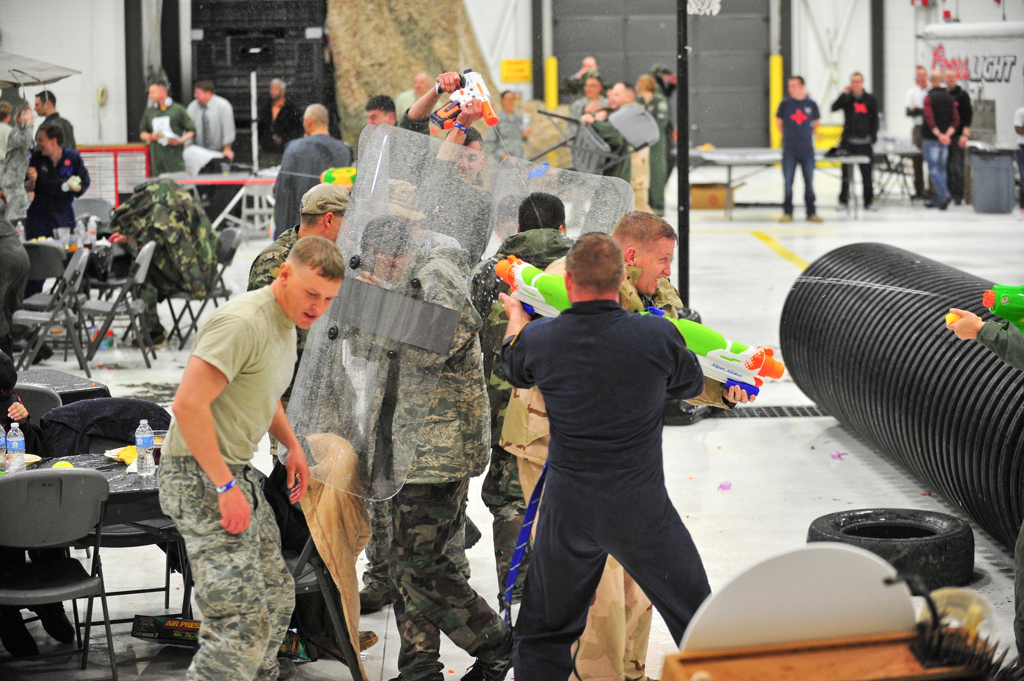 Air Force Reservists  instigate a chaotic water fight March 1, 2014, during the 310th Space Wing's Combat Dining In/Annual Awards Ceremony at Peterson Air Force Base, Colo. The wing sponsored the event to both recognize its annual award winners and bring together the Reservists to enjoy an evening of esprit de corps, unit morale and camaraderie. (U.S. Air Force photo/Tech. Sgt. Nicholas B. Ontiveros)