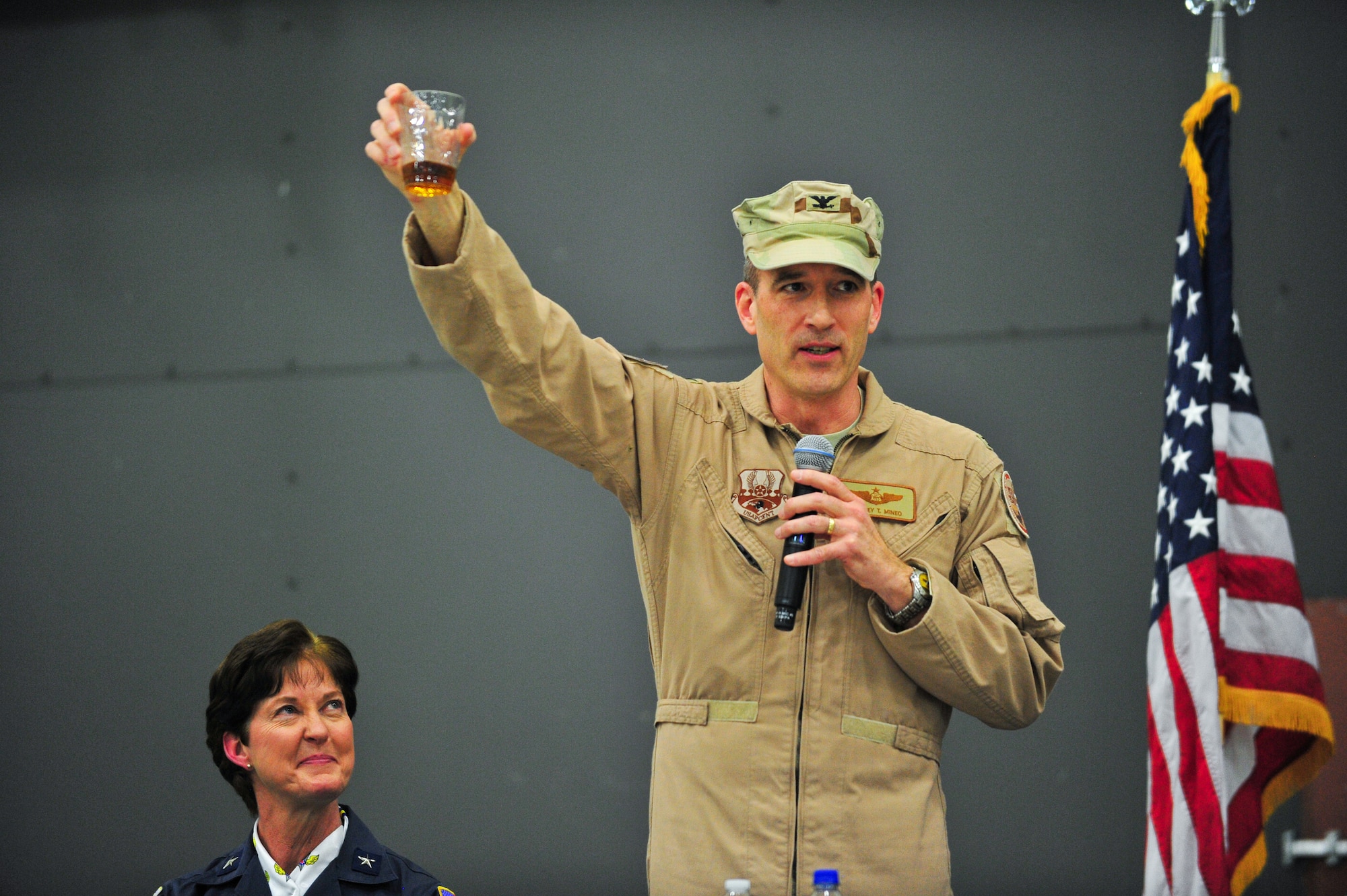 Air Force Reserve Brig. Gen. Karen A. Rizzuti watches AF Reserve Col. Jeffrey T. Mineo as he toasts an anxious audience March 1, 2014, moments before the official start of the 310th Space Wing's Combat Dining In/Annual Awards Ceremony at Peterson Air Force Base, Colo. The wing sponsored the event to both recognize its annual award winners and bring together the Reservists to enjoy an evening of esprit de corps, unit morale and camaraderie. Rizzuti, the Mobilization Assistant to the 24th Air Force commander , was the guest speaker at the event. Mineo is the 310th Space Wing commander. (U.S. Air Force photo/Tech. Sgt. Nicholas B. Ontiveros)