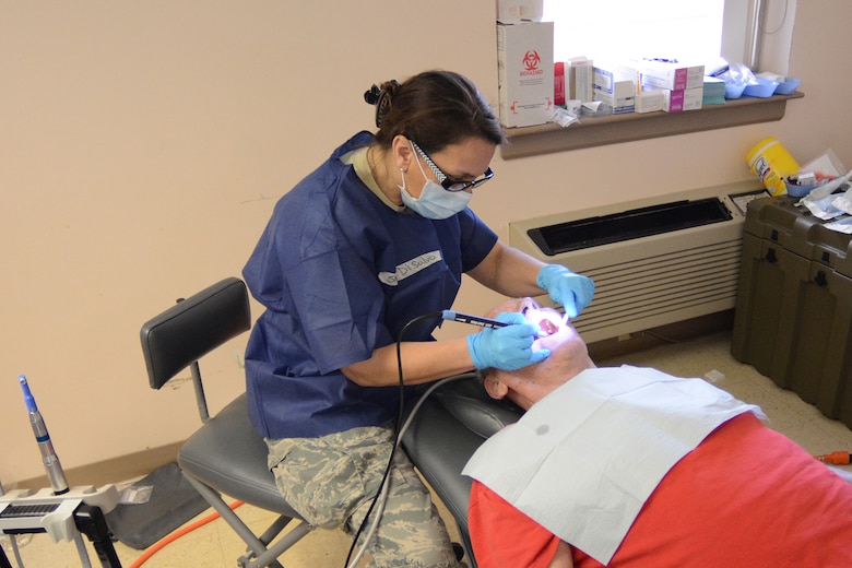 Senior Master Sgt. Lisa DiSalvo, 115th Medical Group superintendent of administrative services, cleans a patient’s teeth during Cajun Care 2014 in Abbeville, La., March 2, 2014. During the 10-day mission, Air National Guard and Navy personnel provided dental, optometry and medical services to more than 2,100 people. (Air National Guard photo by Senior Airman Andrea F. Liechti)