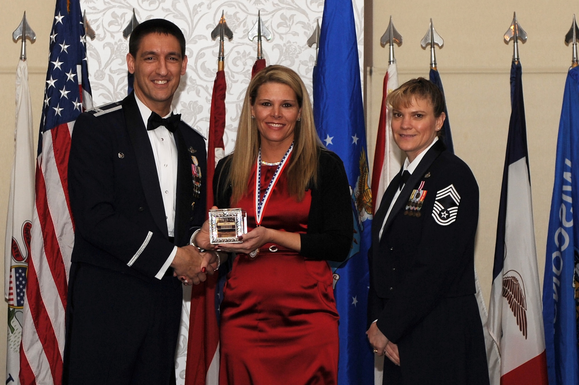 Col. Kyle Kremer and Chief Master Sgt. Teresa Clapper present Yvonne A Callaway with the Wing Spouse of the Year award at Scott Air Force Base. Kremer is the 375th AIr Mobility Wing commander, and Clapper is the interim command chief for the 375th AMW. (U.S. Air Force photo/Senior Airman Divine Cox)