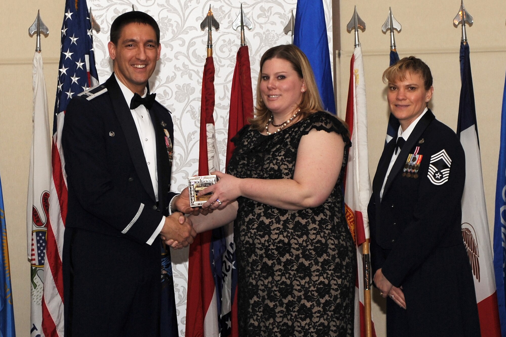 Kremer and Clapper present Meryl Glidwell with the Key Spouse of the Year award. (U.S. Air Force photo/Senior Airman Divine Cox)