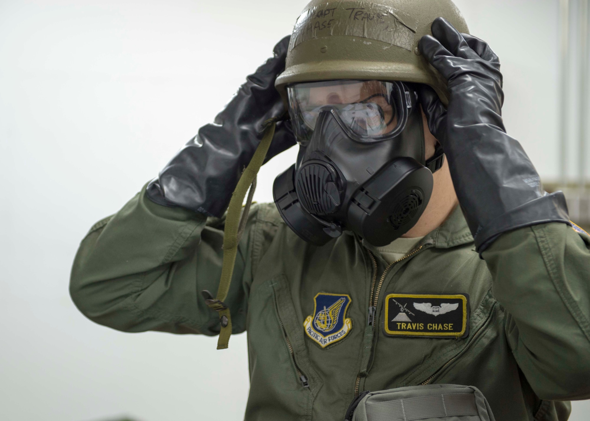 Capt. Travis Chase, 36th Airlift Squadron C-130 navigator, dons his mission-oriented protective posture gear during the Samurai Readiness Inspection at Yokota Air Base, Japan, March 5, 2014.  Many different units throughout Yokota participated in the inspection, ensuring they were prepared to support the Pacific theater under any condition.  (U.S. Air Force photo by Airman 1st Class David Danford / released)