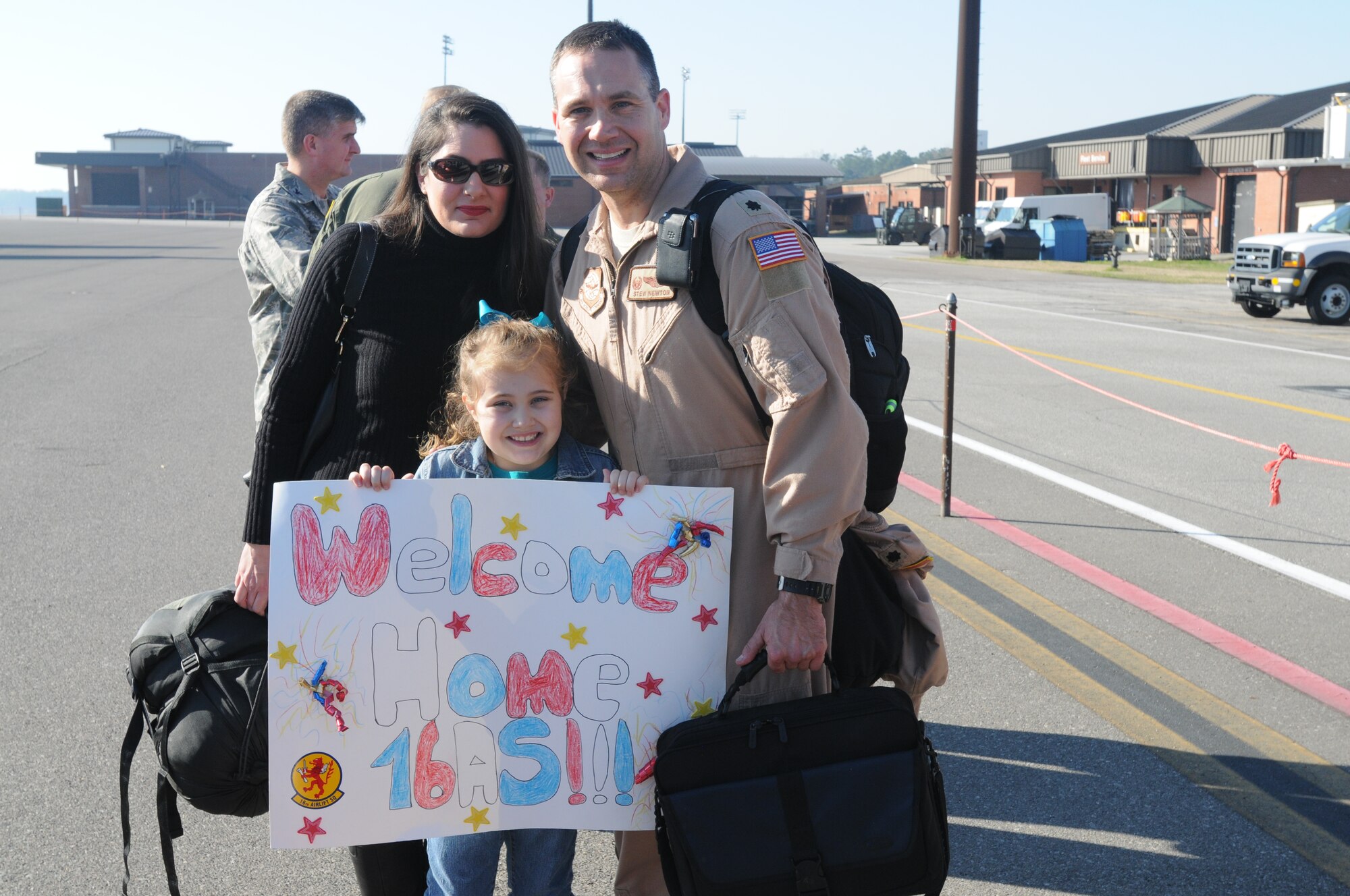 Lt. Col. Stewart Newton, 16th Airlift Squadron, is greeted by his wife Carey and daughter Rachel upon his return from a 60-day deployment. While deployed crews flew and supported more than 1,050 sorties, delivered more than 40 million pounds of cargo to include: 1,135 rolling stock, 2,397 pallets and more than 17,000 passengers. (U.S. Air Force photo/Capt. Sean Perry)