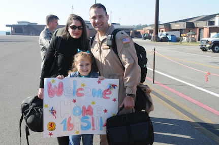 Lt. Col. Stewart Newton, 16th Airlift Squadron, is greeted by his wife Carey and daughter Rachel upon his return from a 60-day deployment. While deployed crews flew and supported more than 1,050 sorties, delivered more than 40 million pounds of cargo to include: 1,135 rolling stock, 2,397 pallets and more than 17,000 passengers. (U.S. Air Force photo/Capt. Sean Perry)