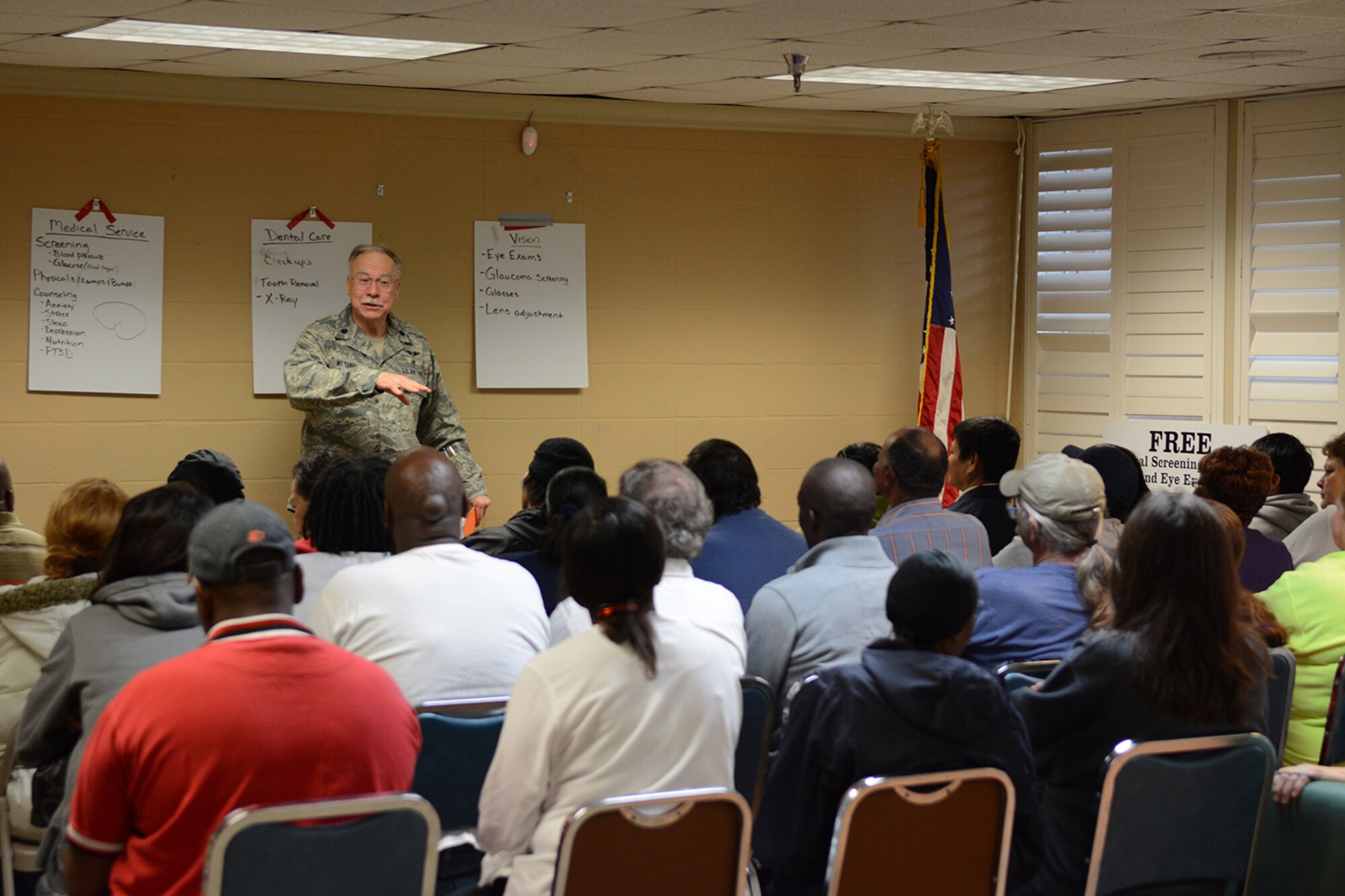 Lt. Col. Brad Meyers, 115th Fighter Wing medical group, briefs patients during Cajun Care 2014 in Abbeville, La., March 2, 2014. Meyers briefed the importance of hand-washing, discussed nutritional advice, encouraged exercise, provided an overview of dental health, recommended tips for preventing falls and encouraged use of bike helmets, seatbelts and car seats. After the briefing was complete, patients were sent to the medical, dental and optometry areas for consultations and treatment, if necessary. (Air National Guard photo by Senior Airman Andrea F. Liechti)