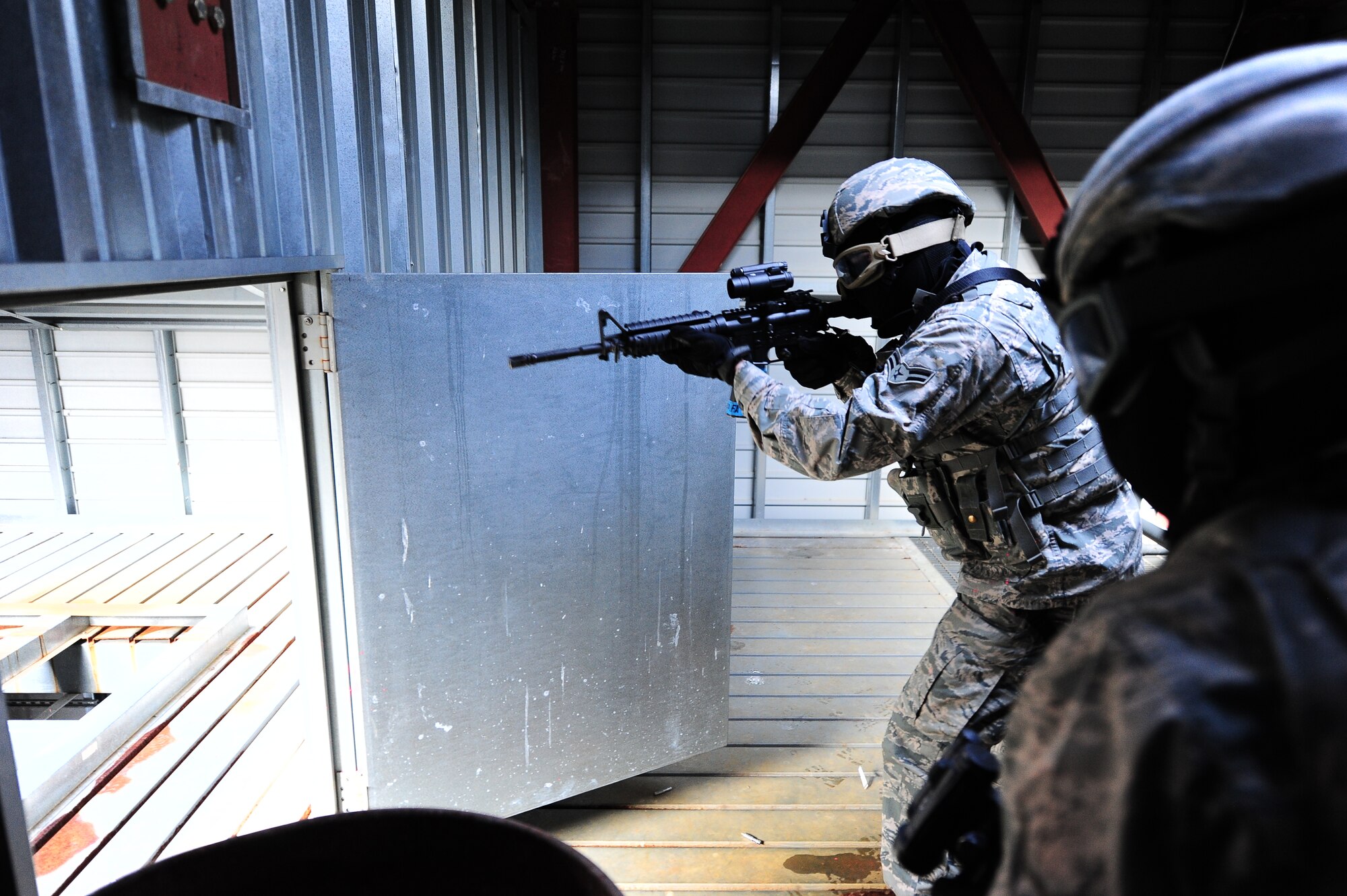 Columbus Air Force Base security personnel brach and clear a room searching for a hostage, here, Feb. 22, 2014. The Airmen were using sim-munition rounds to make the exercise as realistic as possible.