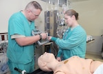 Photo by Steven Galvan
Army Maj. Scott Phillips (left) shows Army Maj. Jodelle Schroeder how to use the Burn Navigator to assist with resuscitating a burn patient during pre-deployment training recently.