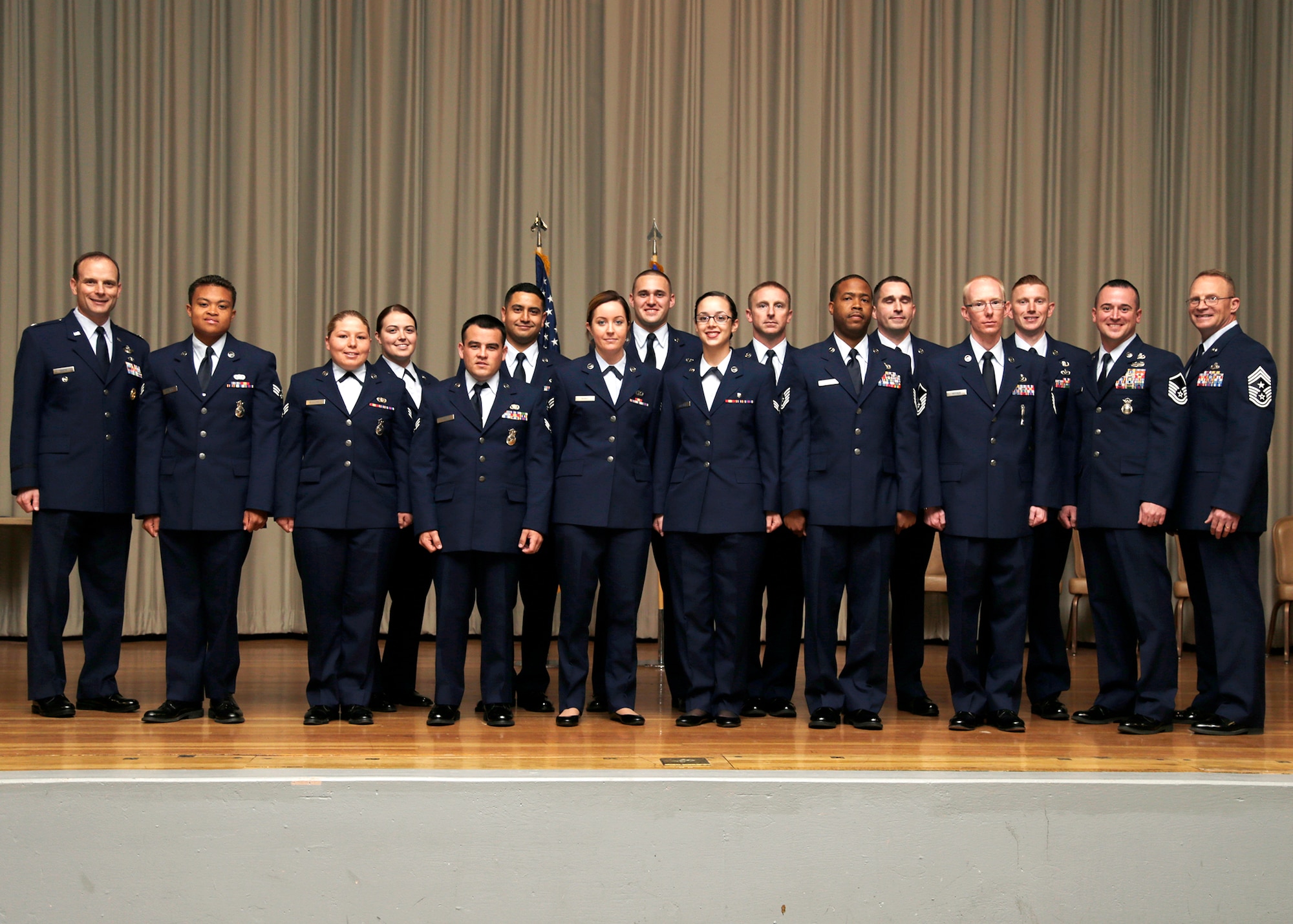 Col. Daniel Daetz, 412th Test Wing vice commander (far left), and Chief Master Sgt. Briand Randolph, 412th TW command chief (far right), pose for a group photo with Team Edwards' newest enlisted promotees and the base theater Feb. 28. (U.S. Air Force photo by Christian Turner)
