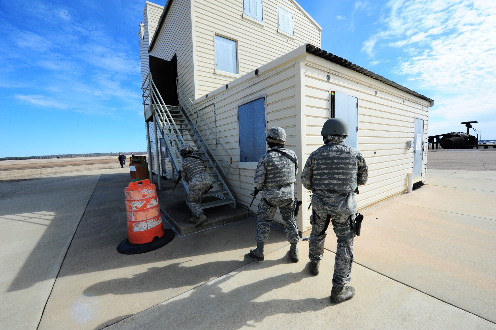 Columbus Air Force Base secuirty personnel tactically circle a building looking for the best entrance, here, Feb. 22, 2014. The aremen were conducting an active shooter excercise durning a law enforcement seminar. (US Air Force photo by/Airman 1st Class Daniel Lile)