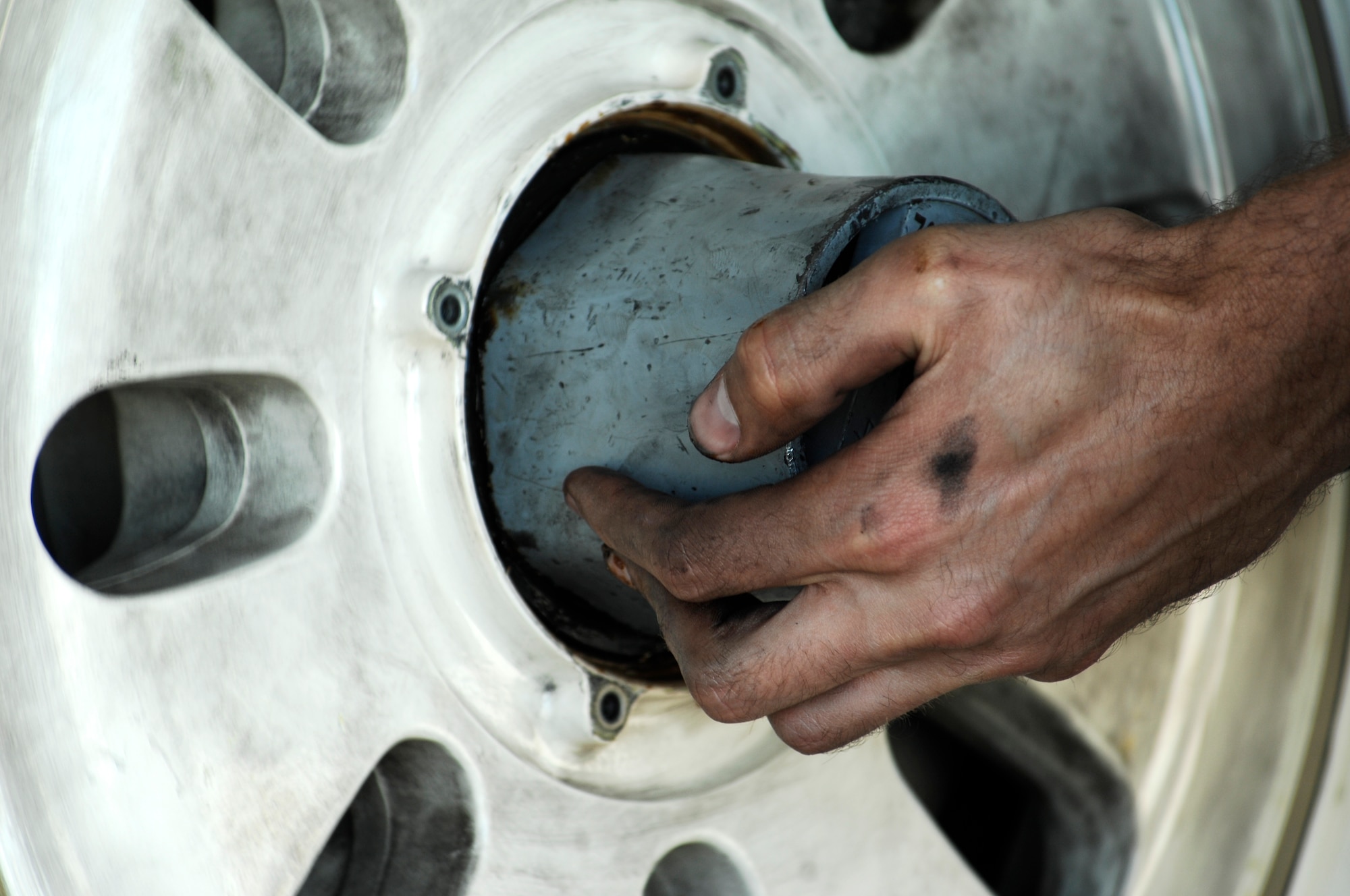 Staff Sgt. Robert Mackle, 49th Aircraft Maintenance Squadron F-22 Raptor crew chief from Holloman Air Force Base, N.M., spins a Raptor tire on the wheel hub during a tire change on the flightline at Davis-Monthan Air Force Base., Ariz. March 2, 2014. Mackle was one of the two-man F-22 Maintenance Recovery Team members that traveled six hours from Holloman Air Force Base, N.M. to replace the aircraft’s specific tires. (U.S. Air Force photo by: Staff Sgt. Angela Ruiz)(Released)