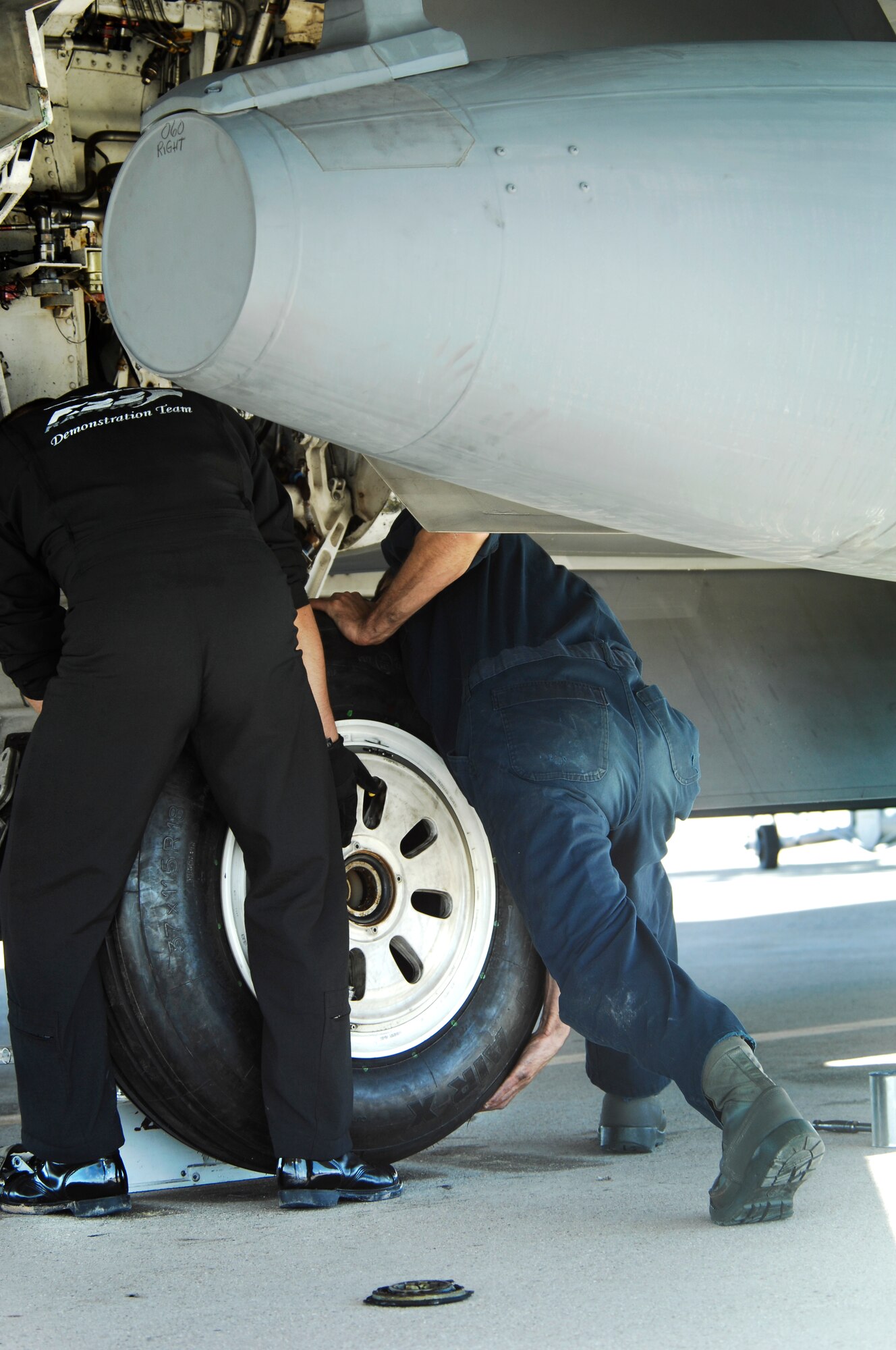 U.S. Air Force Tech. Sgt. Harrison Southworth, Air Combat Command F-22 Raptor Demonstration Team crew chief and Staff Sgt. Robert Mackle., 49th Aircraft Maintenance Squadron F-22 crew chief from Holloman Air Force Base, N.M., replaces an F-22 Raptor tire on the flightline at Davis-Monthan Air Force Base., Ariz. March 2, 2014. The F-22 Demonstration Team from Langley Air Force Base, V.A., were here participating in Heritage Flight Training Course 2014 and were able recover the aircraft upon arrival and assist the Holloman AFB Maintenance Recovery team in replacing the tires. (U.S. Air Force photo by Staff Sgt. Angela Ruiz/Released)
