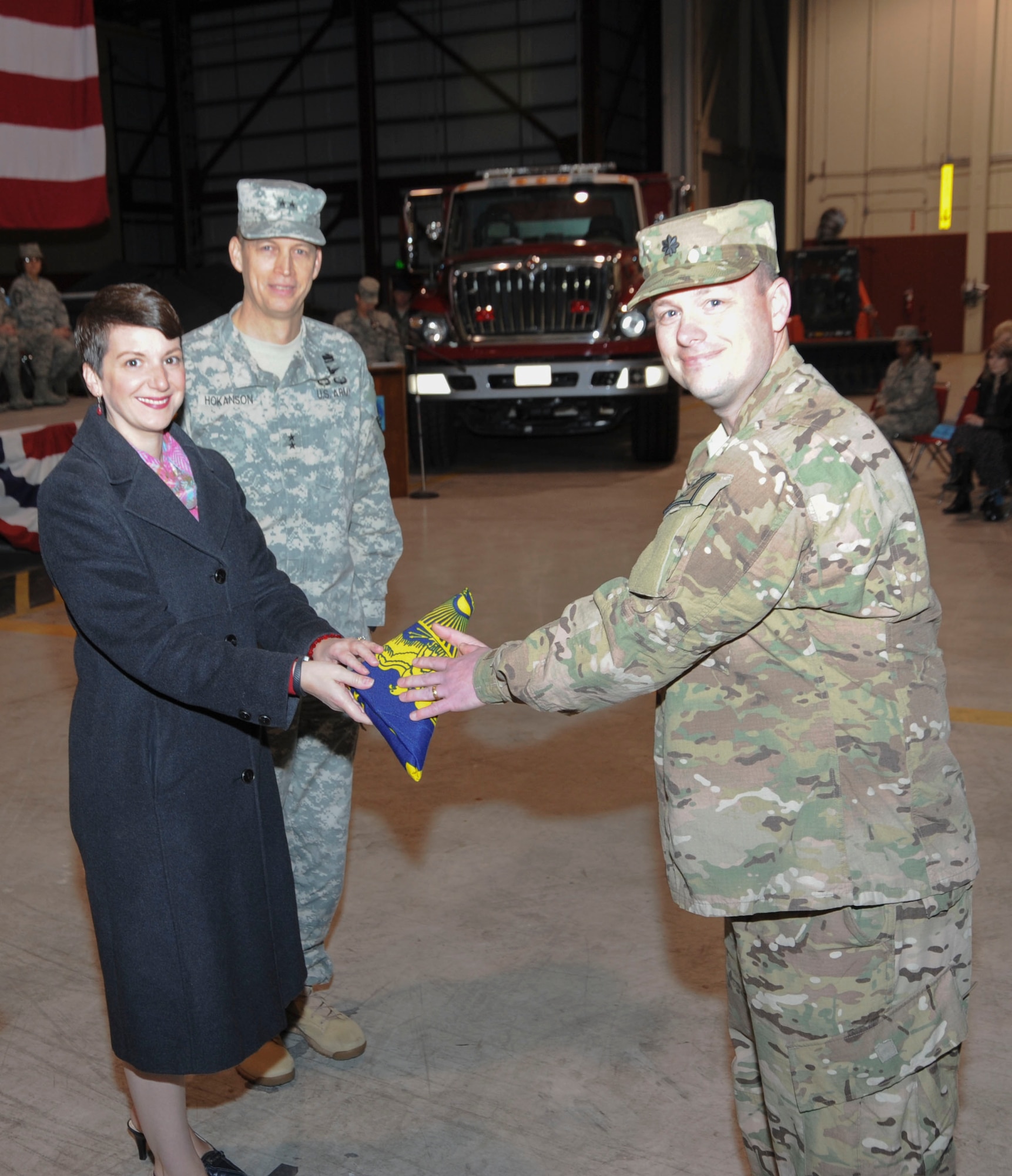 Oregon Air National Guard Lt. Col. Jason Lay, 142nd Fighter Wing Civil Engineer Squadron Commander is presented the State of Oregon flag by State of Oregon Public Safety Policy Advisor, Heidi Moawad, during their mobilization ceremony held at the Portland Air National Guard Base, Ore., March 1. (Air National Guard Photo by Tech. Sgt. Aaron Perkins, 142nd Fighter Wing Public Affairs/Released)