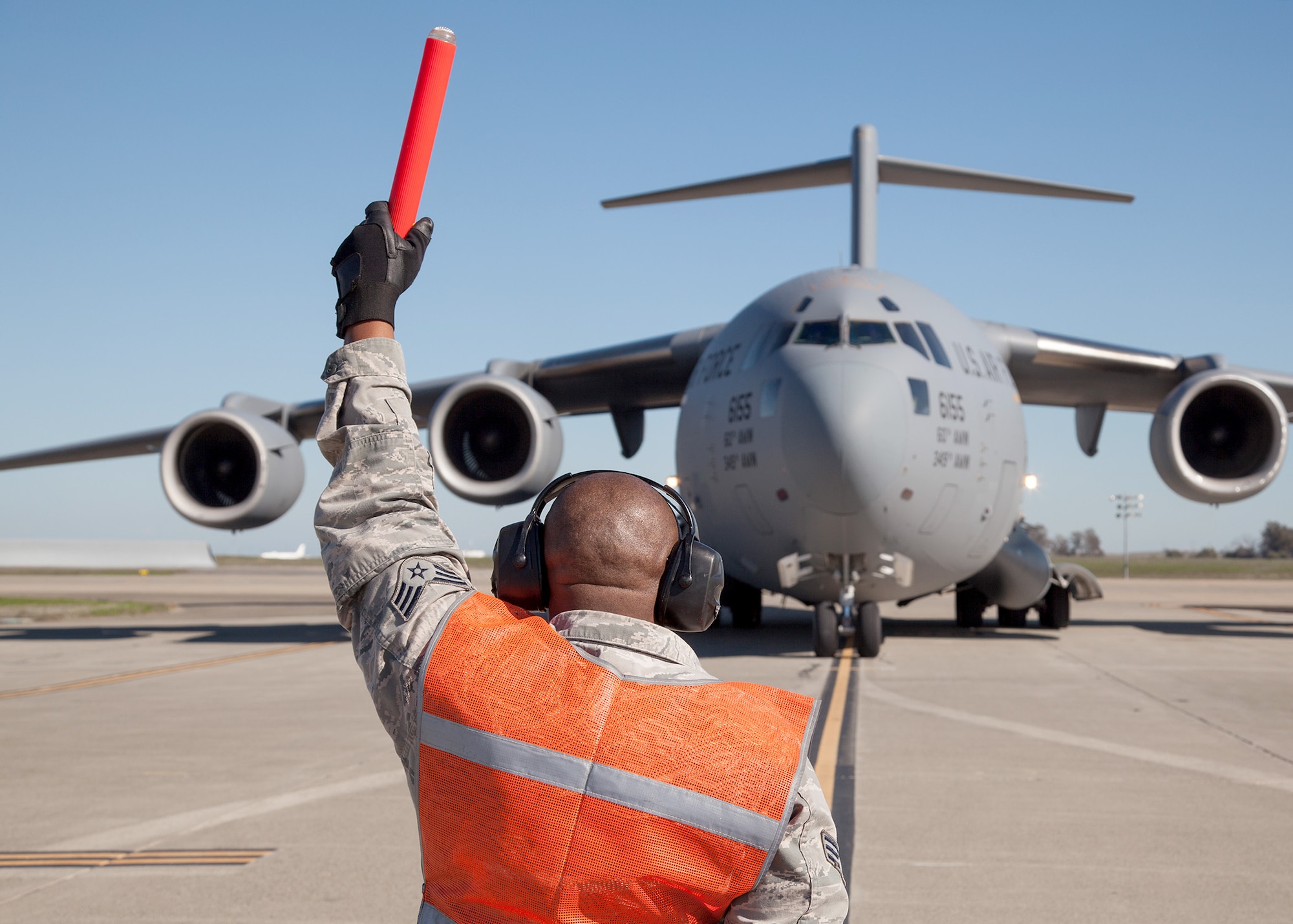 TRAVIS AIR FORCE BASE, Calif. -- Senior Airman Kwame T. Ntutela, a crew chief with the 945th Aircraft Maintenance Squadron, recovers a C-17 Globemaster III at at Travis Air Force Base, Calif., Feb. 23, 2014. During the Unit Training Assembly of Feb. 22-23, squadrons from across the 349th Air Mobility Wing conducted interrelated exercise scenarios, providing Reservists opportunities to achieve core skill proficiency training.   On this particular aeromedical evacuation sortie,  key training events were achieved for members from the 349th Operations, Maintenance, Support and Medical Groups. (U.S. Air Force photo / Lt. Col. Robert Couse-Baker)
