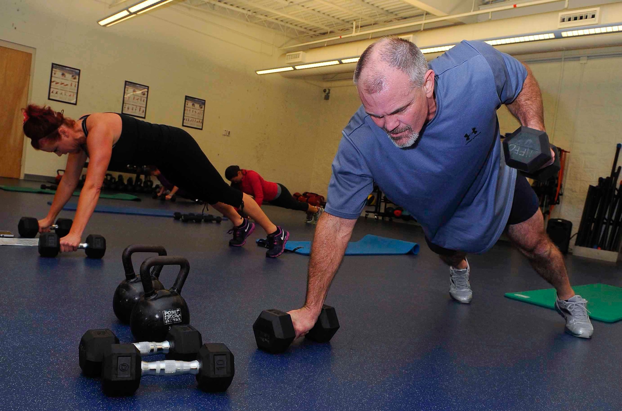 Keith Thompson, Bootcamp Express student, and Lisa Pizzo, lead group fitness instructor, work out at the Aderholt Gym on Hurlburt Field, Fla., March 3, 2014. The class challenges strength and endurance by incorporating weights into short-interval workouts. (U.S. Air Force photo/Airman 1st Class Andrea Posey)