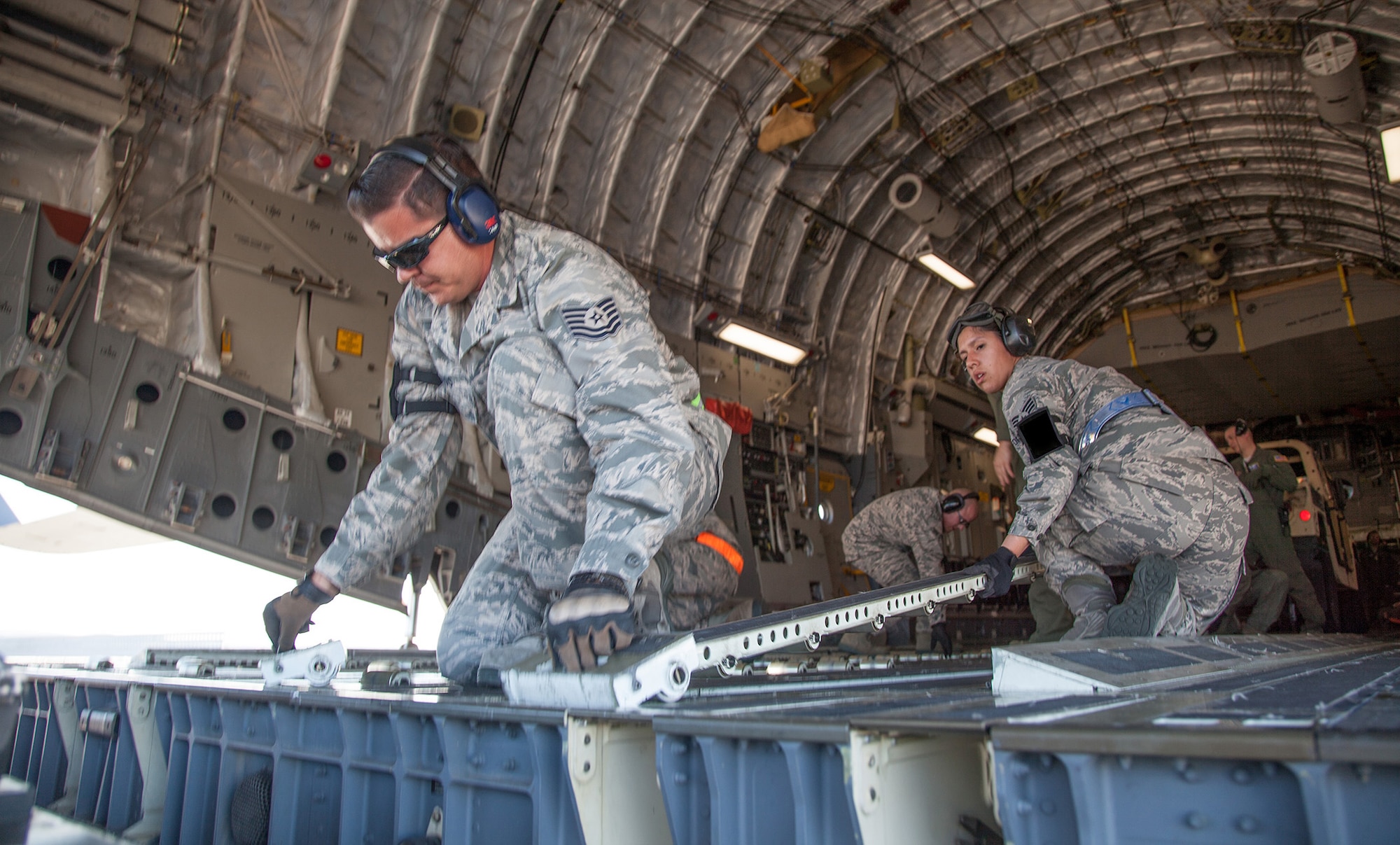 TRAVIS AIR FORCE BASE, Calif. -- Tech. Sgt. Nathan A. Larios (left), an air transportation specialist with the 55th Aerial Port Squadron,  and Senior Airman Alyssa L. Pafford, an air transportation specialist with the 82nd APS, change the configuration of a C-17 Globemaster III cargo ramp from pallets to rolling stock at Travis Air Force Base, Calif., Feb. 23, 2014. During the Unit Training Assembly of Feb. 22-23, squadrons from across the 349th Air Mobility Wing conducted interrelated exercise scenarios, providing Reservists opportunities to achieve core skill proficiency training.   On this particular C-17 Globemaster III aeromedical evacuation sortie,  key training events were achieved for members from the 349th Operations, Maintenance, Support and Medical Groups. (U.S. Air Force photo / Lt. Col. Robert Couse-Baker)