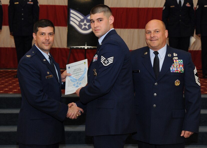 Staff Sgt. Alexander Costanzo, 2nd Security Forces Squadron, receives a certificate of promotion from Col. Andrew Gebara, 2nd Bomb Wing commander, and Chief Master Sgt. Stephen Lebrun, 2nd Operations Group, during the February Wing Promotion Ceremony on Barksdale Air Force Base, La., Feb. 28, 2014. (U.S. Air Force photo/Senior Airman Joseph A. Pagán Jr.)