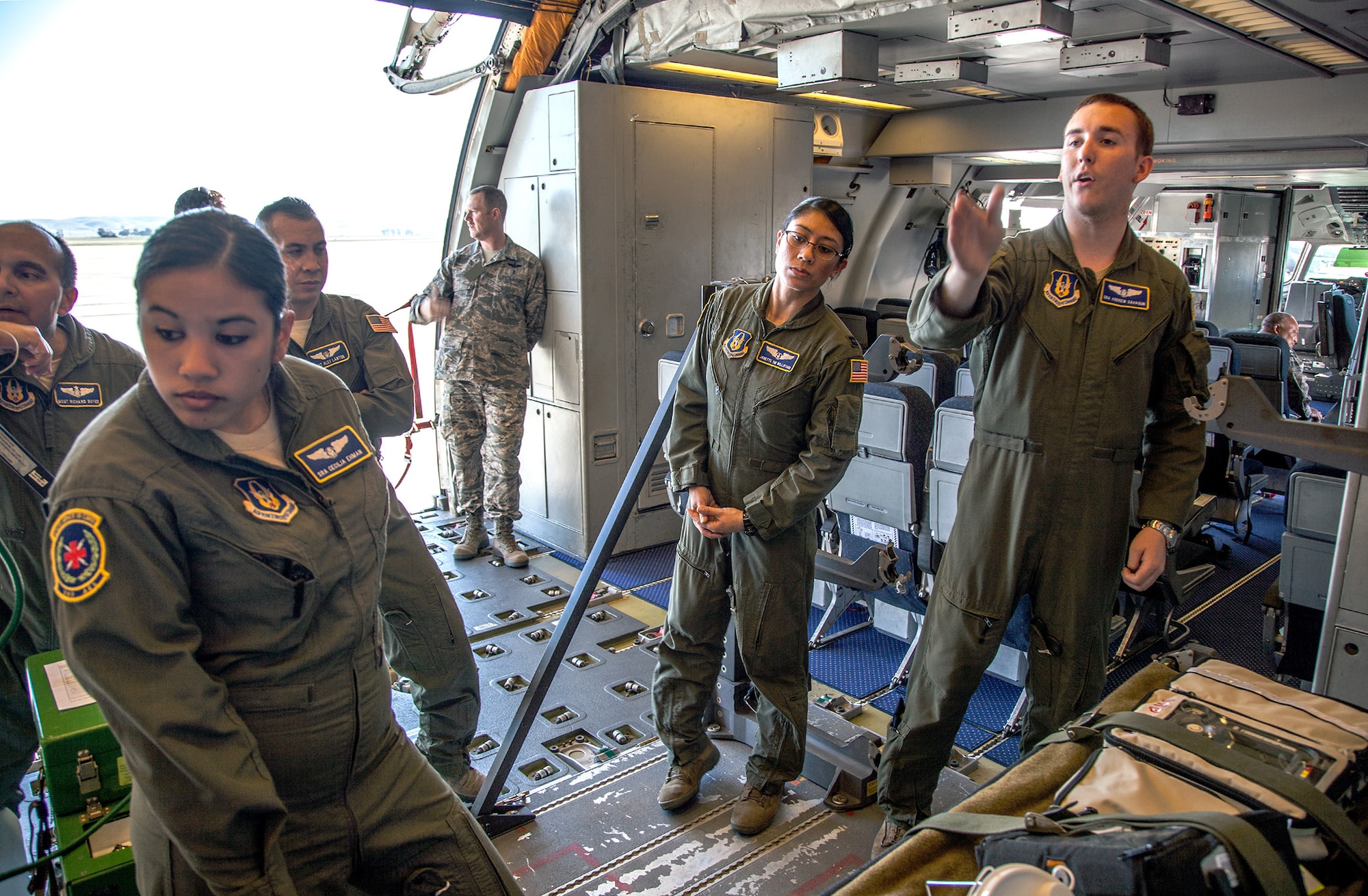 TRAVIS AIR FORCE BASE, Calif. -- Senior Airman Andrew P. Sahagun (right), an aeromedical evacuation specialist with the 349th Aeromedical Evacuation Squadron, conducts a training class on the specialized procedures for using a KC-10A Extender for opportune aeromedical evaluation at Travis Air Force Base, Calif., Feb. 23, 2014.   Capt. Janette S. Williford (center), flight nurse and Senior Airman Cecilia A. Ehman (left), aeromedical evacuation specialist, participate in the class. Unlike the C-17 Globemaster III, the KC-10 was not designed with aeromedical evaluation in mind, but can be configured for the mission when needed. During the Unit Training Assembly of Feb. 22-23, squadrons from across the 349th Air Mobility Wing conducted interrelated exercise scenarios, providing Reservists opportunities to achieve core skill proficiency training. (U.S. Air Force photo / Lt. Col. Robert Couse-Baker)