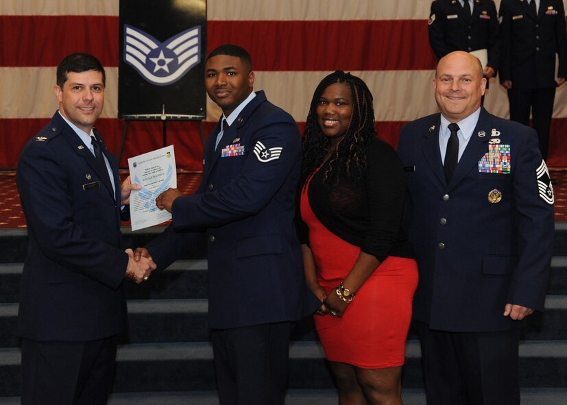 Staff Sgt. Ronald Holmes II, 2nd Force Support Squadron, receives a certificate of promotion from Col. Andrew Gebara, 2nd Bomb Wing commander, and Chief Master Sgt. Stephen Lebrun, 2nd Operations Group, during the February Wing Promotion Ceremony on Barksdale Air Force Base, La., Feb. 28, 2014. (U.S. Air Force photo/Senior Airman Joseph A. Pagán Jr.)