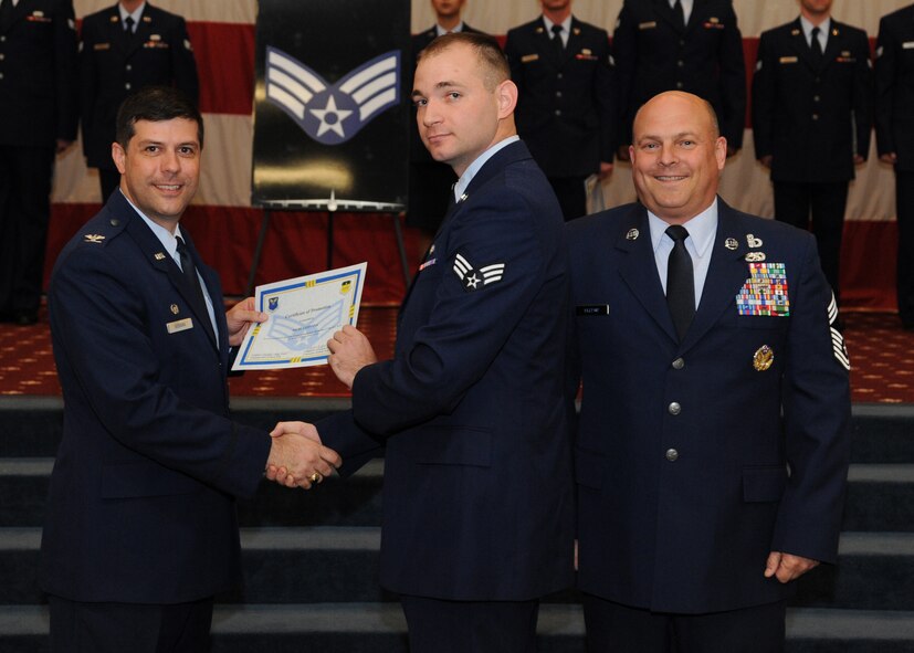 Senior Airman Merl Ledvina, 26th Operational Weather Squadron, receives a certificate of promotion from Col. Andrew Gebara, 2nd Bomb Wing commander, and Chief Master Sgt. Stephen Lebrun, 2nd Operations Group, during the February Wing Promotion Ceremony on Barksdale Air Force Base, La., Feb. 28, 2014. (U.S. Air Force photo/Senior Airman Joseph A. Pagán Jr.)